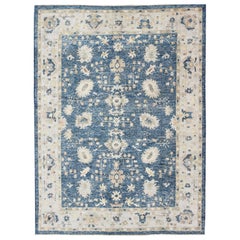 Türkischer Oushak-Teppich mit blauem Hintergrund, neutralen Farben und All-Over-Design
