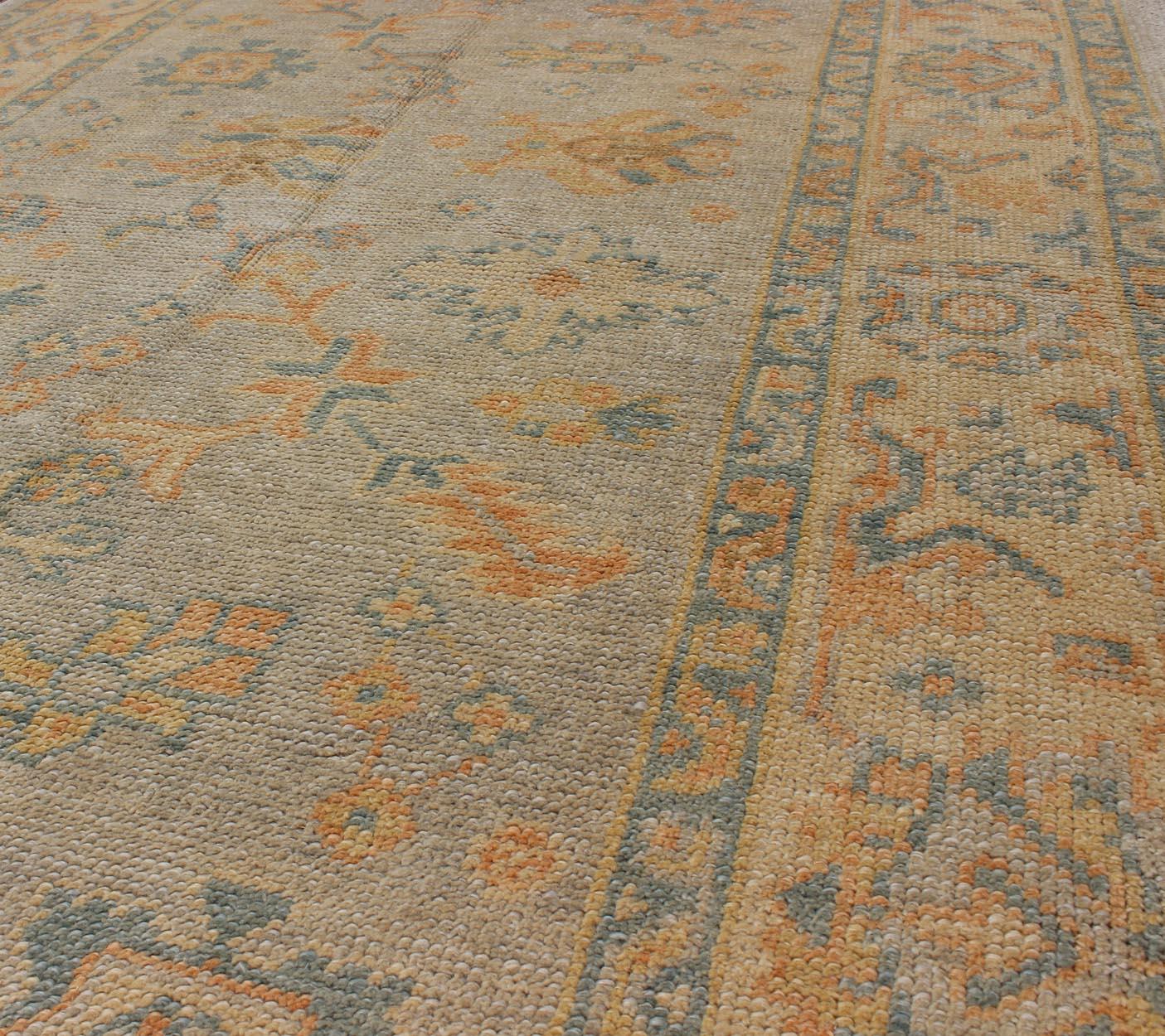 Turco Tappeto turco Oushak con colori verdi e neutri e disegno floreale all-over in vendita