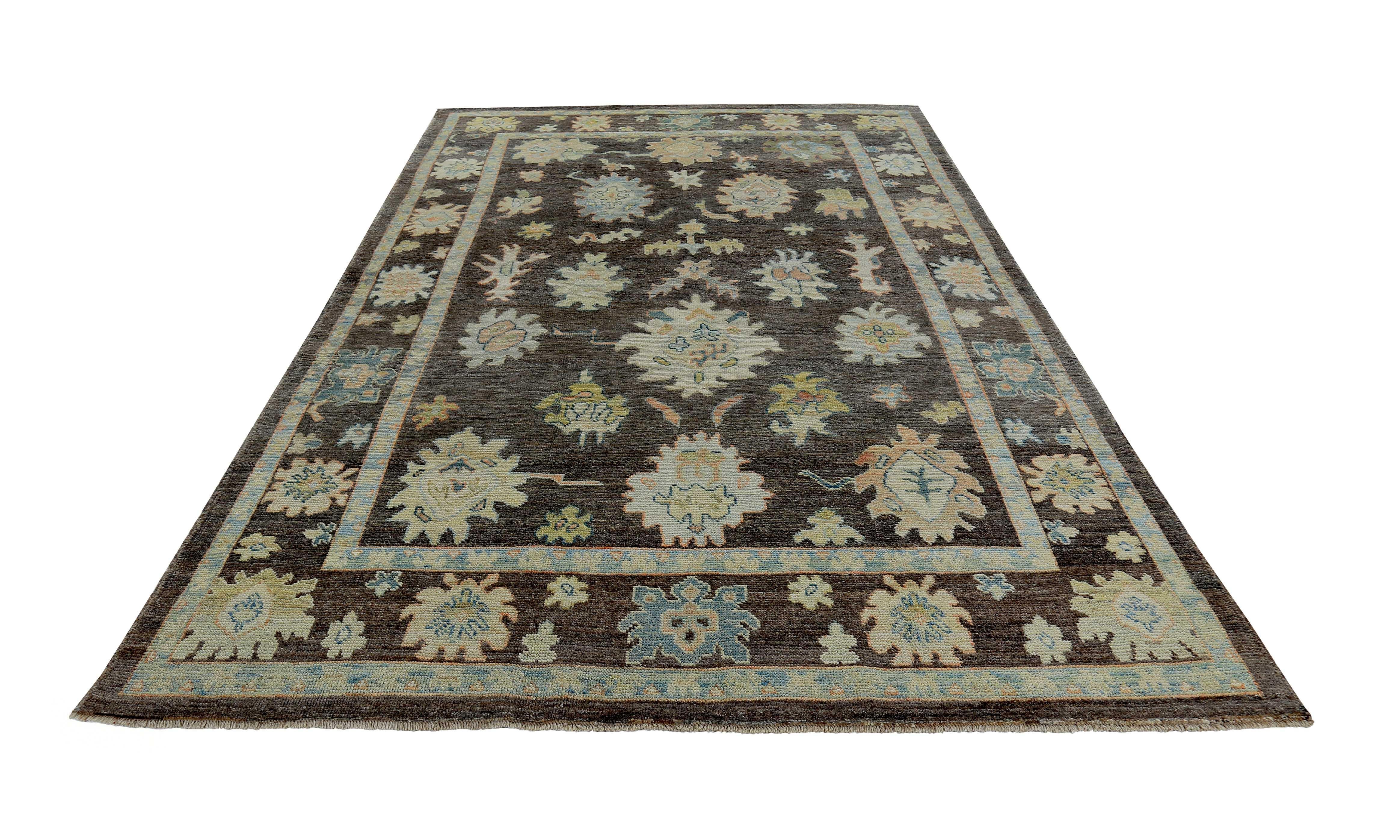 New Turkish rug made of handwoven sheep’s wool of the finest quality. It’s colored with organic vegetable dyes that are certified safe for humans and pets alike. It features ivory, pink, and blue floral details on a lovely brown field. Flower