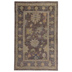 Tapis turc Oushak avec des têtes de fleurs orange, vertes et bleues sur fond brun