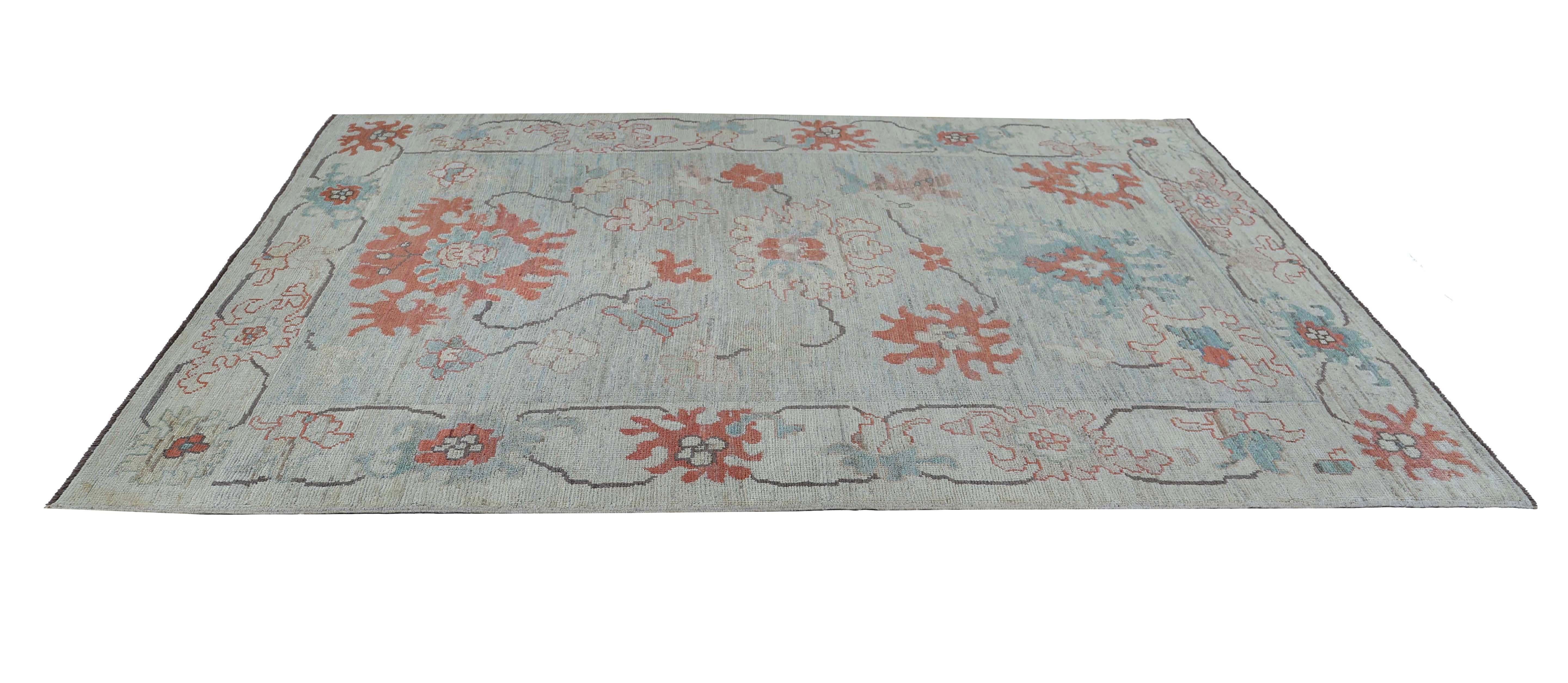 Añade un toque de encanto exótico a tu sala de estar con esta impresionante alfombra turca, que mide 1,80 m por 1,80 m. La alfombra presenta un diseño vibrante, con medallones naranjas sobre un fondo azul cielo relajante, que crea una sensación de