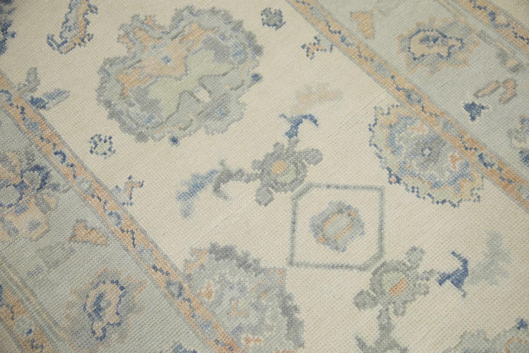 Dieser türkische Oushak-Läufer aus dem frühen 21. Jahrhundert ist ein handgewebtes Meisterwerk, das mit traditionellen Techniken hergestellt wurde. Der Teppich zeigt komplizierte Blumenmotive in einer sanften blauen und apricotfarbenen Farbpalette,