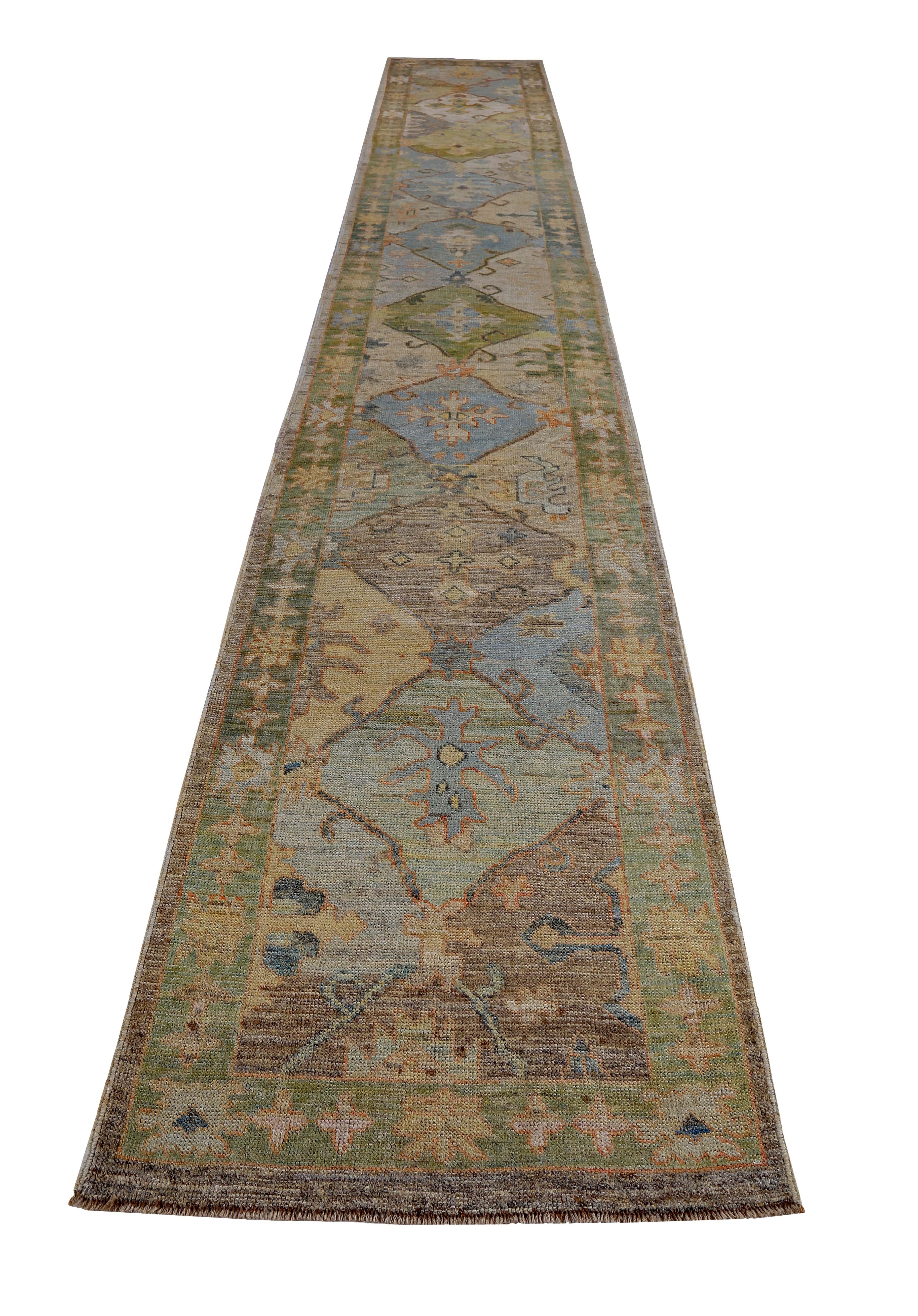 Turkish runner rug made of handwoven sheep’s wool of the finest quality. It’s colored with organic vegetable dyes that are certified safe for humans and pets alike. It features blue and orange floral patterns on a beautiful brown and green field.