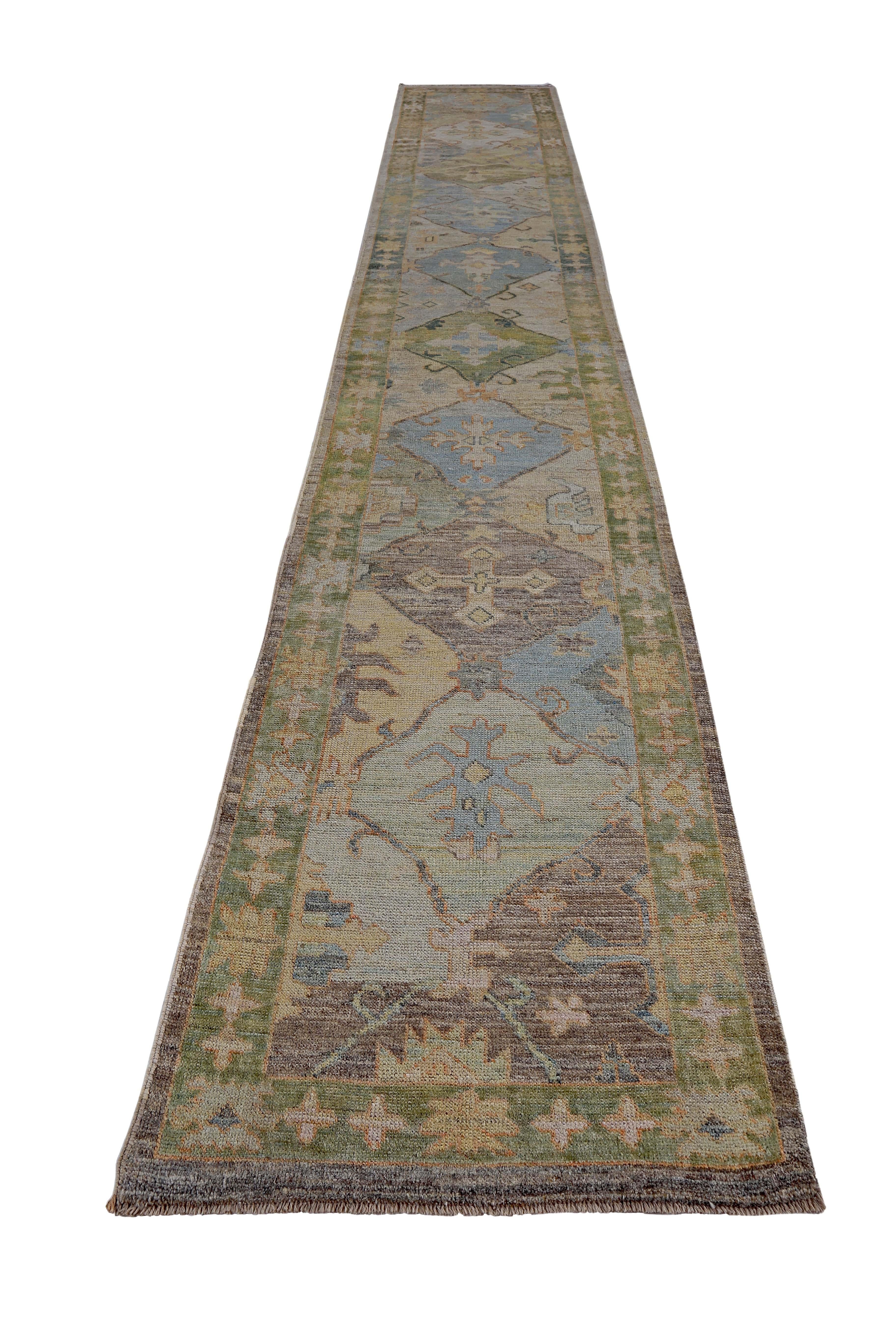 Turkish runner rug made of handwoven sheep’s wool of the finest quality. It’s colored with organic vegetable dyes that are certified safe for humans and pets alike. It features beige and blue floral patterns on a beautiful brown and green field.