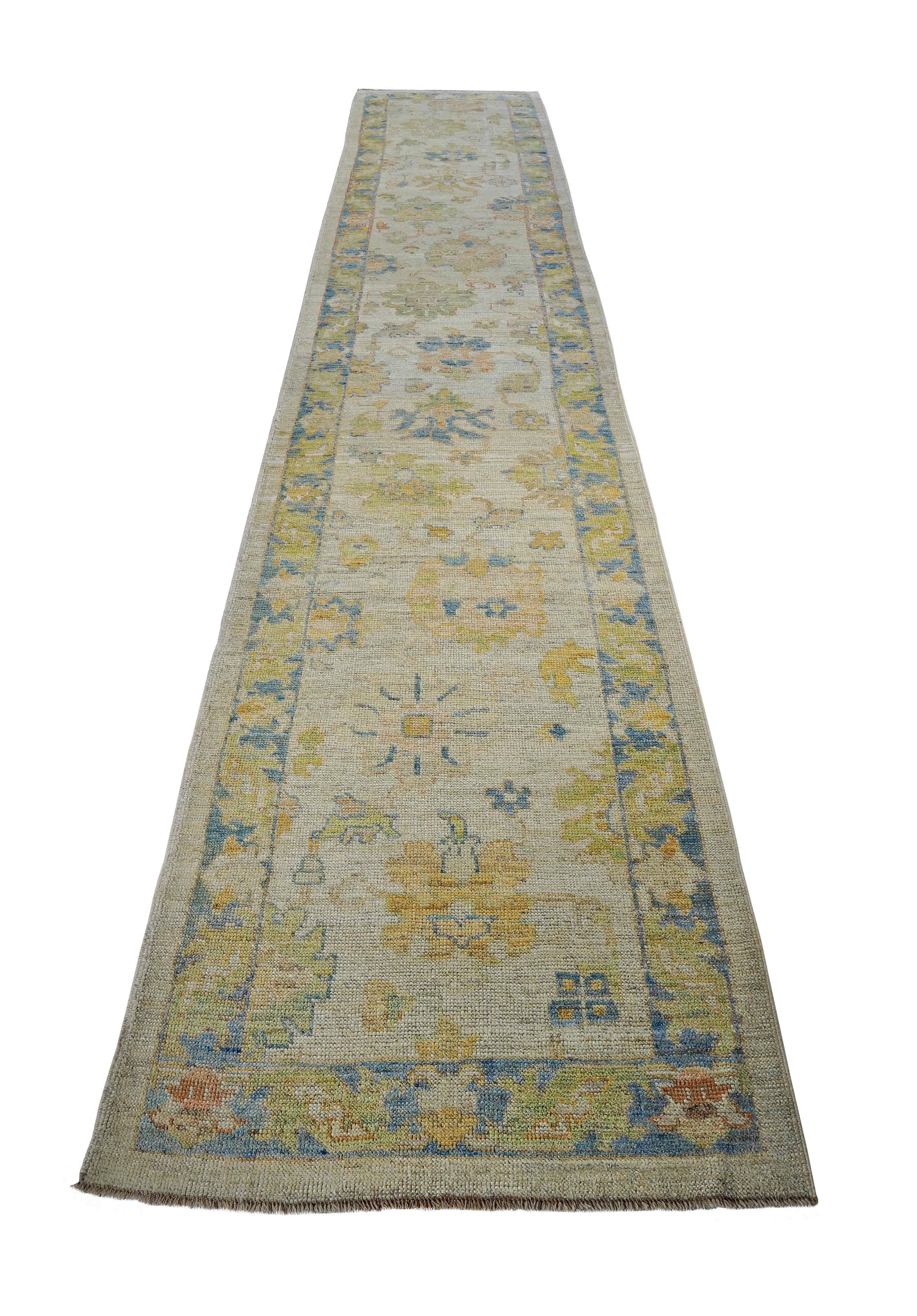 New Turkish runner rug made of handwoven sheep’s wool of the finest quality. It’s colored with organic vegetable dyes that are certified safe for humans and pets alike. It features blue and green floral details on an ivory field. Flower patterns are