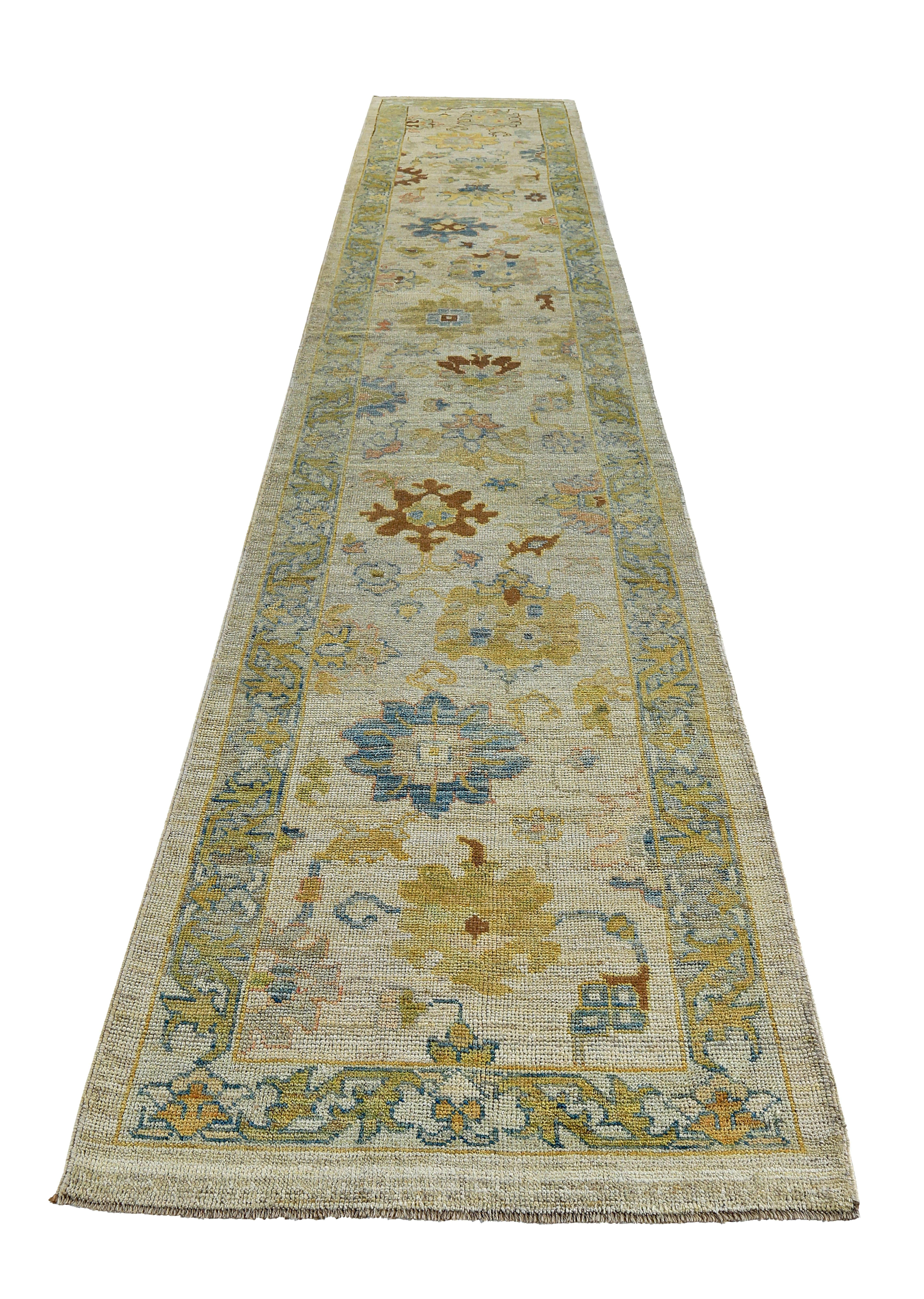 Turkish runner rug made of handwoven sheep’s wool of the finest quality. It’s colored with organic vegetable dyes that are certified safe for humans and pets alike. It features gold and blue floral details on a lovely ivory field. Flower patterns
