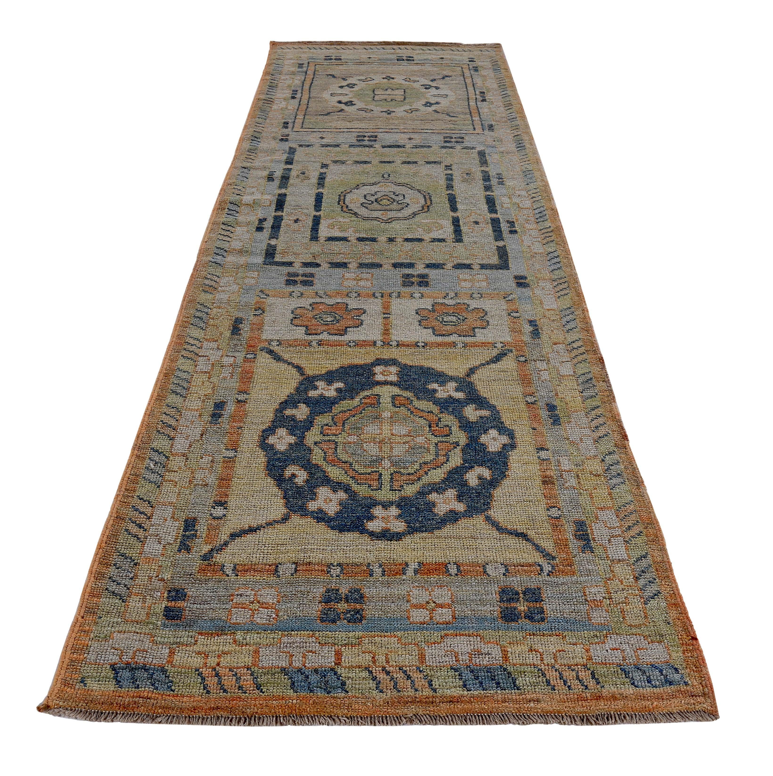 Turkish runner rug made of handwoven sheep’s wool of the finest quality. It’s colored with organic vegetable dyes that are certified safe for humans and pets alike. It features navy and green floral patterns on a beautiful blue and orange field.