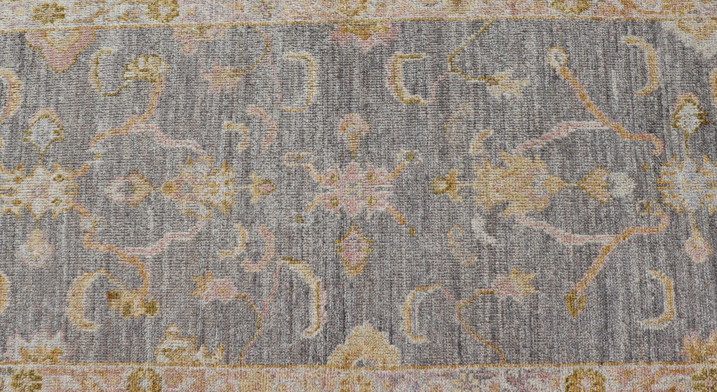 Dieser türkische Oushak-Läufer hat einen schönen stahlblauen Hintergrund und eine cremefarbene Bordüre. Das arabeskenartige Blumenmuster erstreckt sich über das gesamte Feld und ist in den eleganten Farben Ringelblume, Rosa und Creme gehalten.