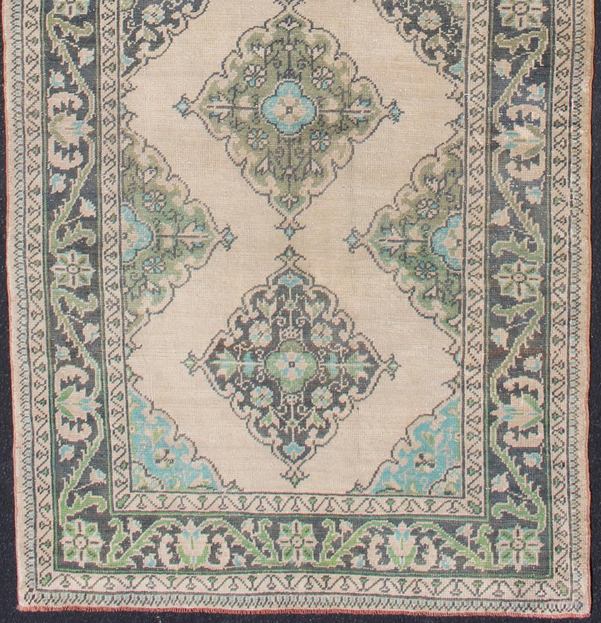 Turkish Oushak runner with Medallion design in dark blue, blush, aqua and green.
Floral Medallion design Oushak runner from Turkey, rug en-176969, country of origin / type: Turkey / Oushak, circa 1950

This dynamic Oushak Turkish features a