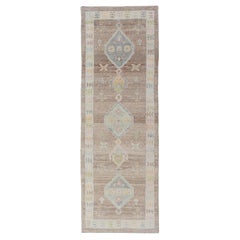 Runner turco in Oushak con campo morbido marrone e medaglioni geometrici blu pallido