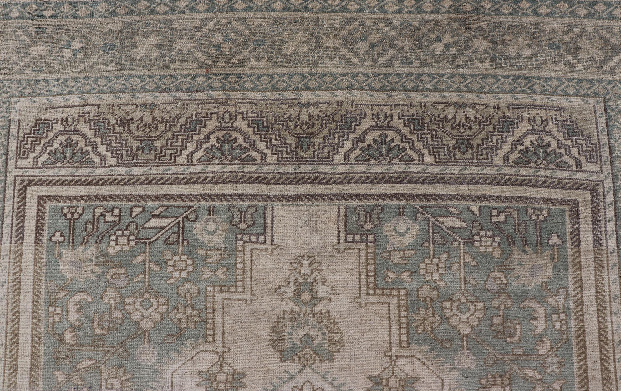Turkish Oushak Vintage Medallion rug in Light Blue-Green, Tan, Taupe, and Cream. Keivan Woven Arts. rug EN-179303, country of origin / type: Turkey / Oushak, circa 1940

This beautiful vintage Oushak rug from 1940s Turkey features a medallion