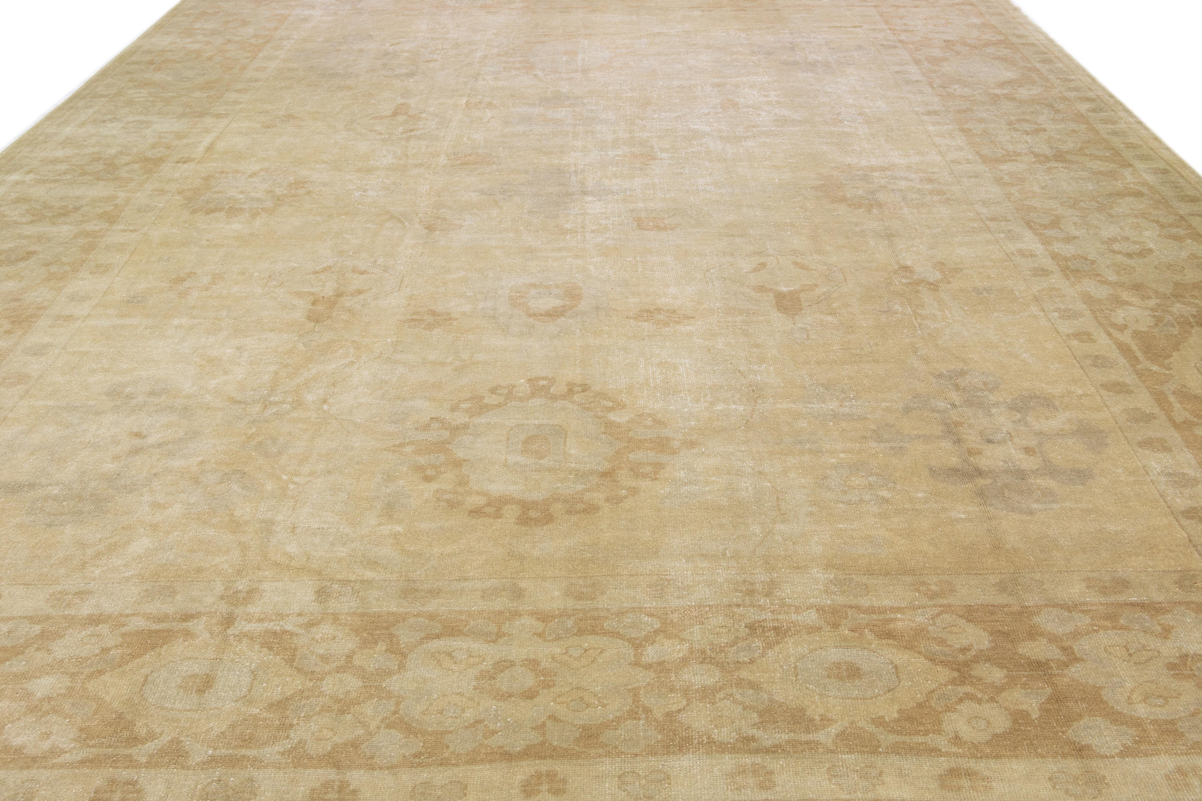 Dieser Oushak-Teppich aus Wolle aus der Türkei präsentiert einen zeitgenössischen Stil und zeigt ein verführerisches Blumenmotiv in gedämpften Grau- und Beigetönen.

Dieser Teppich misst 13'3 