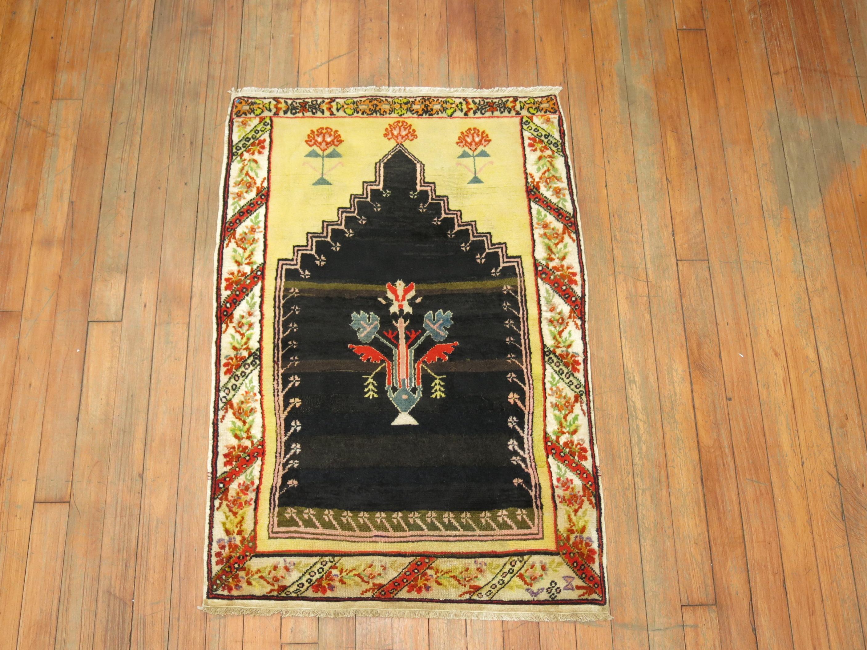 A one of a kind decorative Turkish rug with a prayer niche motif featuring on an unusual black color field.