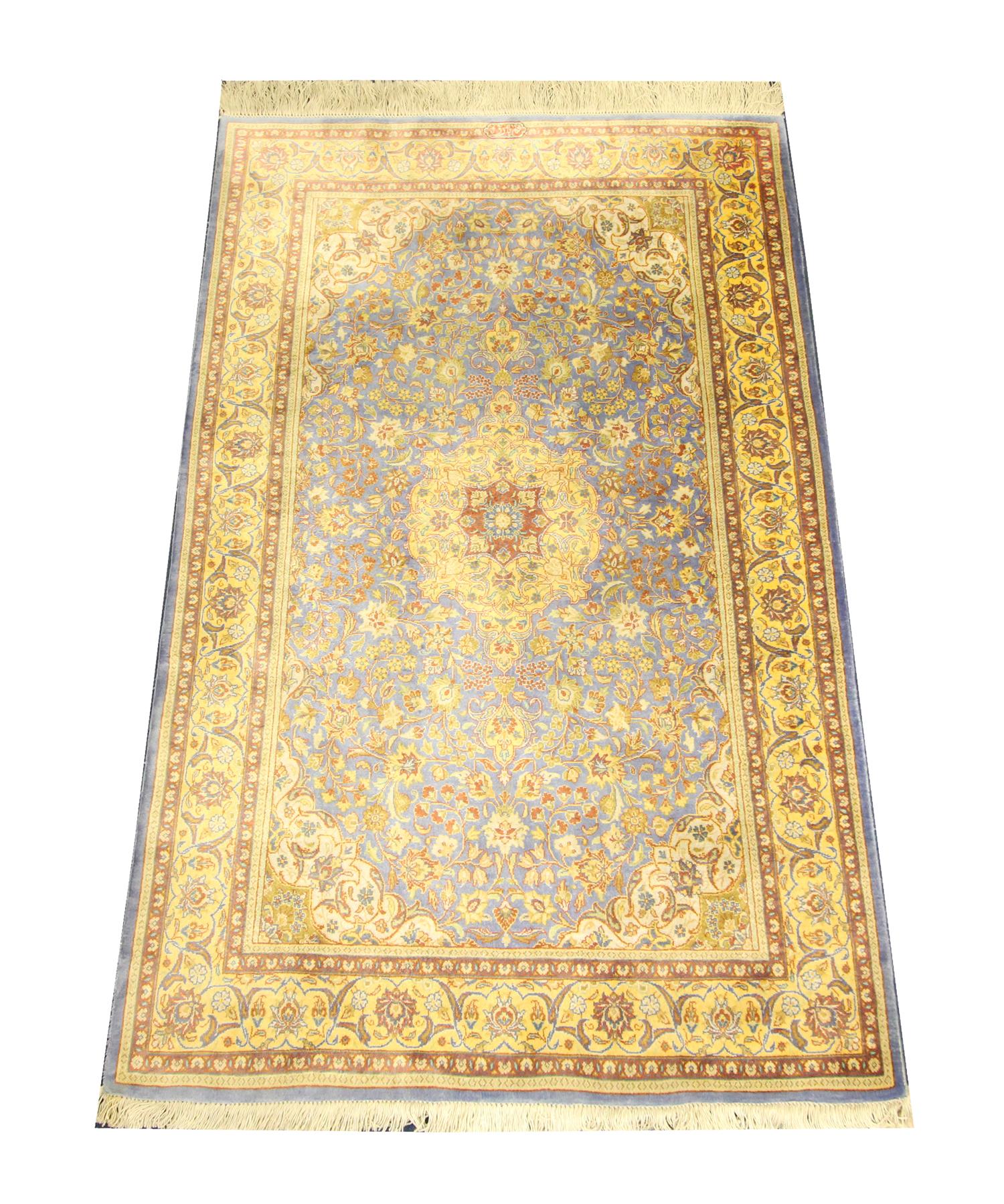 This luxurious grey silk rug was woven by hand in Turkey in the 1990s. The central design has been woven on a grey background with a large medallion and surrounding decorative design woven in beige, gold, and cream accents. This fine oriental rug