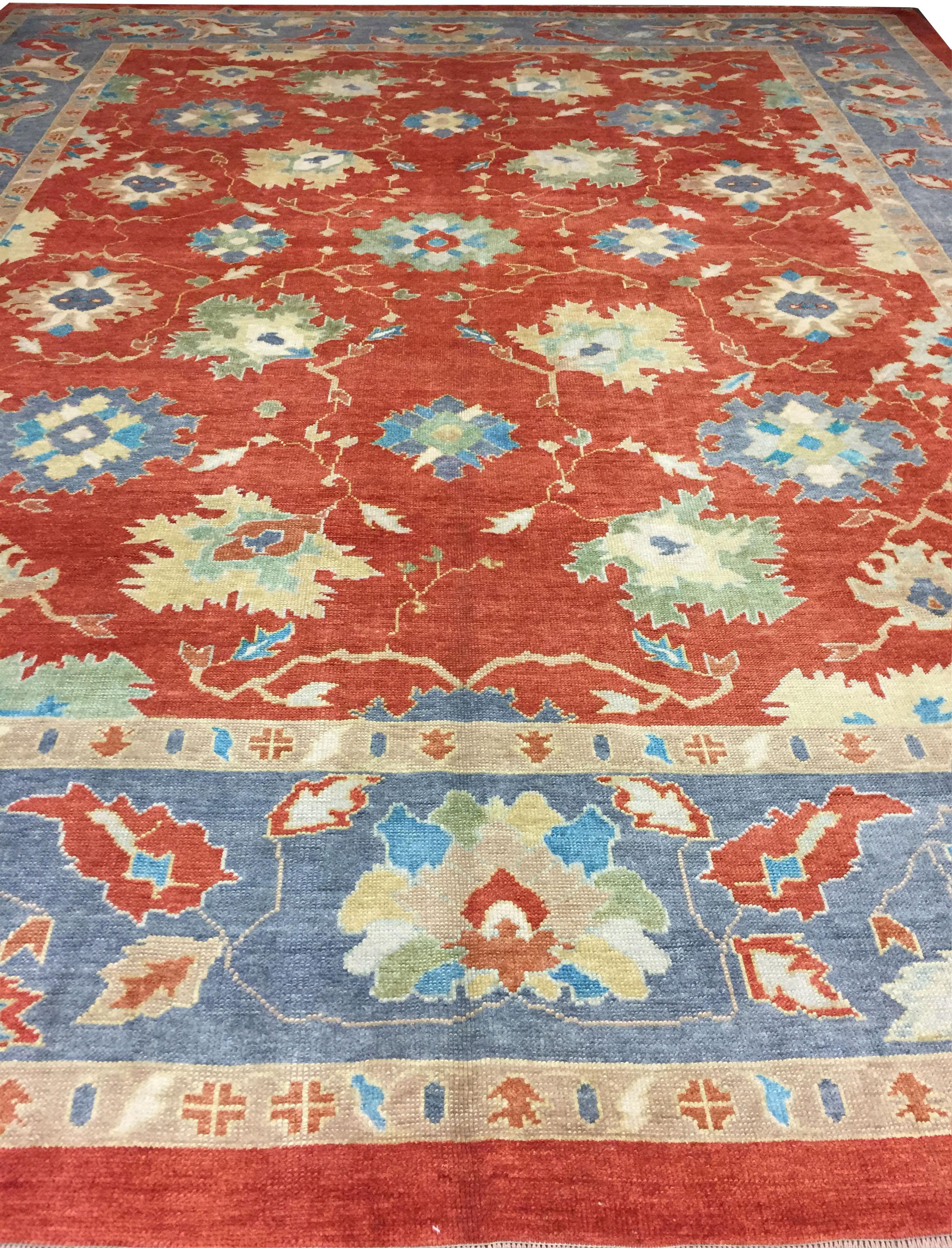 12'10 x 16'1. Charakter, Tradition, Muster und Farbpalette verschmelzen in diesem wunderschönen, handgeknüpften türkischen Oushak-Teppich aus neuer Produktion mit weichen Farben. Die Farben sind Tomate/Stahlblau/Weichgrün/Elfenbein.