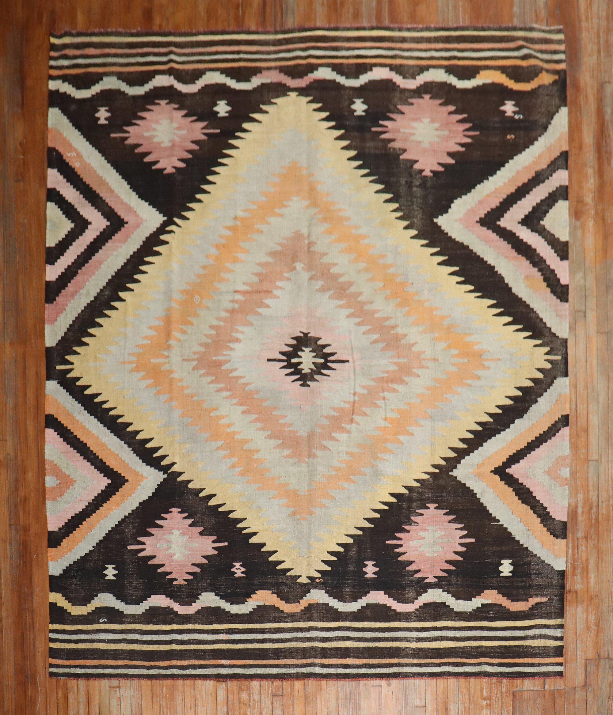 Room size Turkish Kilim from the mid-20th century. The field is brown, accents in canteloupe, peach, light green and lavender.

Measures: 9' x 11'2''.