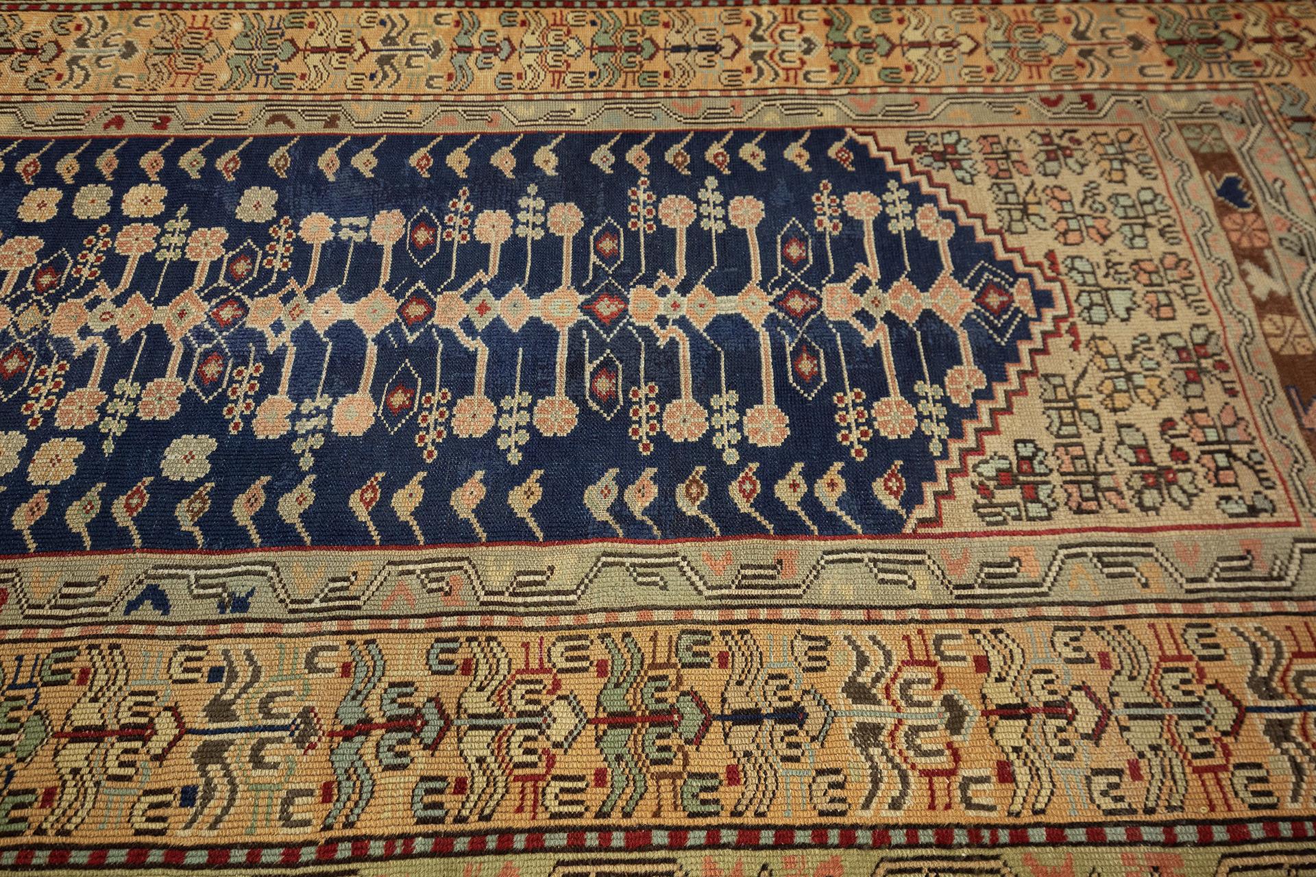 Dieser türkische Kula-Gebetsteppich mit den Maßen 202 x 129 cm ist ein exquisites Beispiel für traditionelle anatolische Handwerkskunst. Das zentrale Feld mit einer tiefblauen Gebetsnische ist mit symmetrischen floralen und geometrischen Motiven