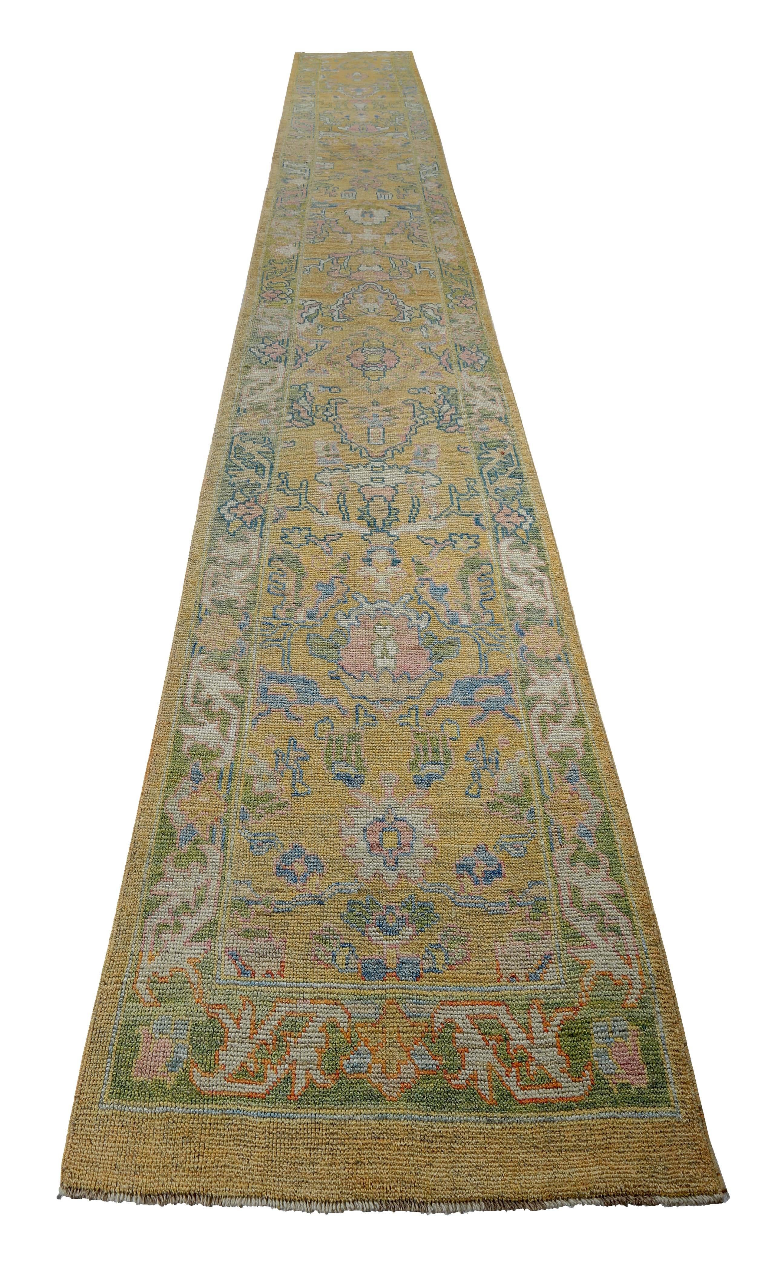 Turkish runner rug made of handwoven sheep’s wool of the finest quality. It’s colored with organic vegetable dyes that are certified safe for humans and pets alike. It features blue and pink floral details on a lovely golden yellow field. Flower