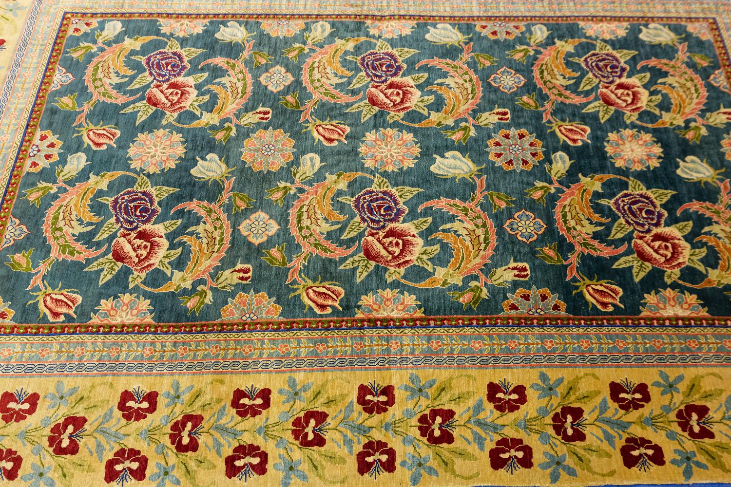 This is a silk and metal threaded Hereke rug woven in Turkey circa 1950-1970 and measures 147 x 87 cm in size. It has an allover floral design with two columns of blossoming rose motifs set on a green background color. The border is decorated with