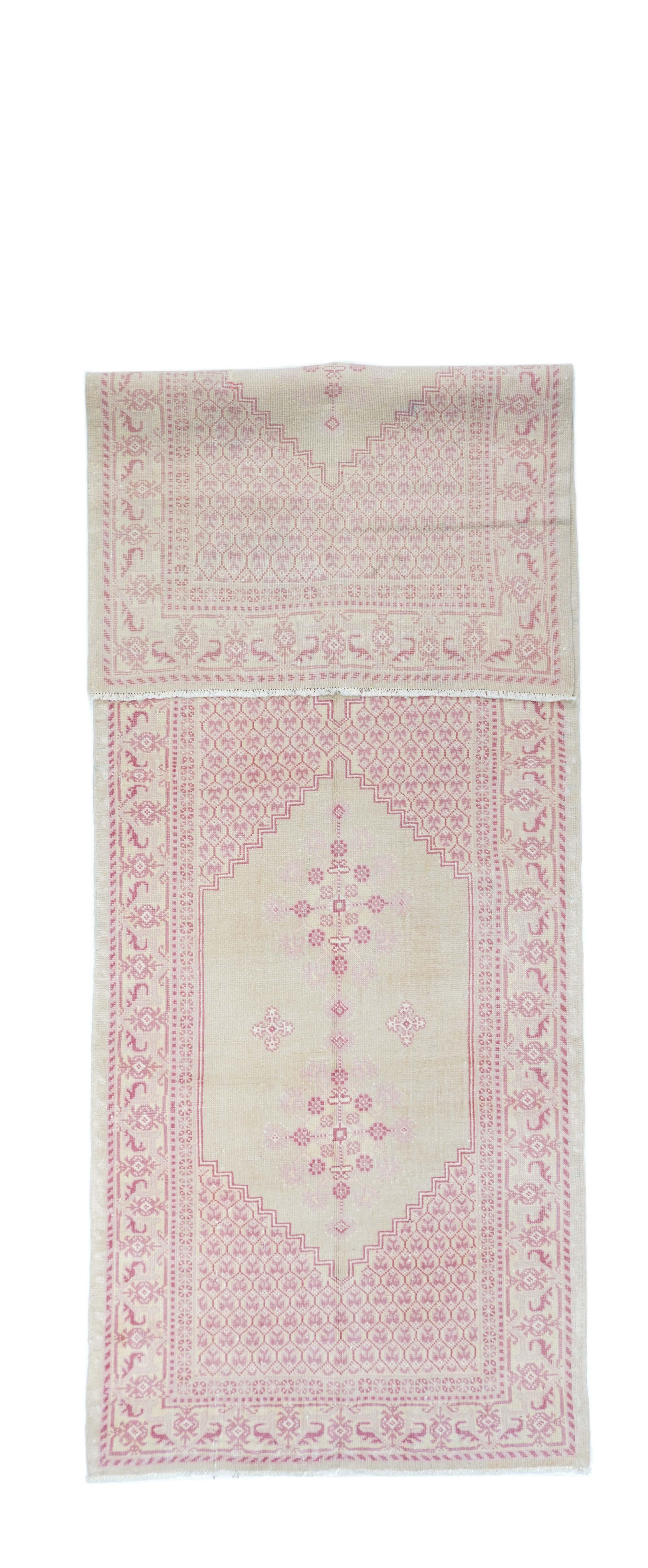 This eastern Turkish vintage town kellegi (long rug) shows a softer palette manifested by two partially stepped open sand-straw hexagons, with honeycomb sections between and at the ends. Two radiating rosette arrays in each panel. Sand border with