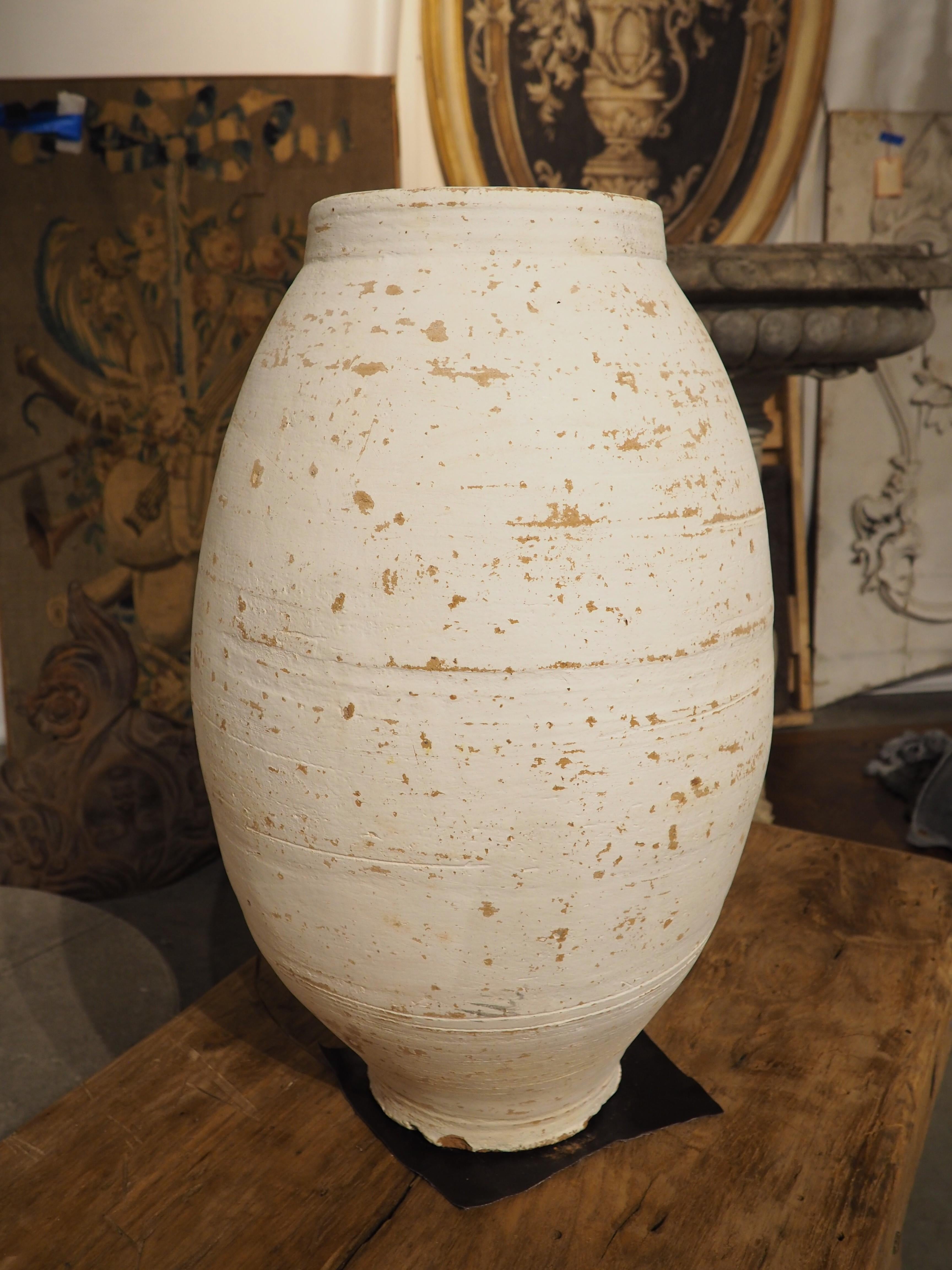 Often found in the Mediterranean areas of Southern Europe, Northern Africa, and Western Asia, olive pots have been used for centuries to store grains and oils for cooking. This particular tall, slender terra cotta pot is a contemporary offering from