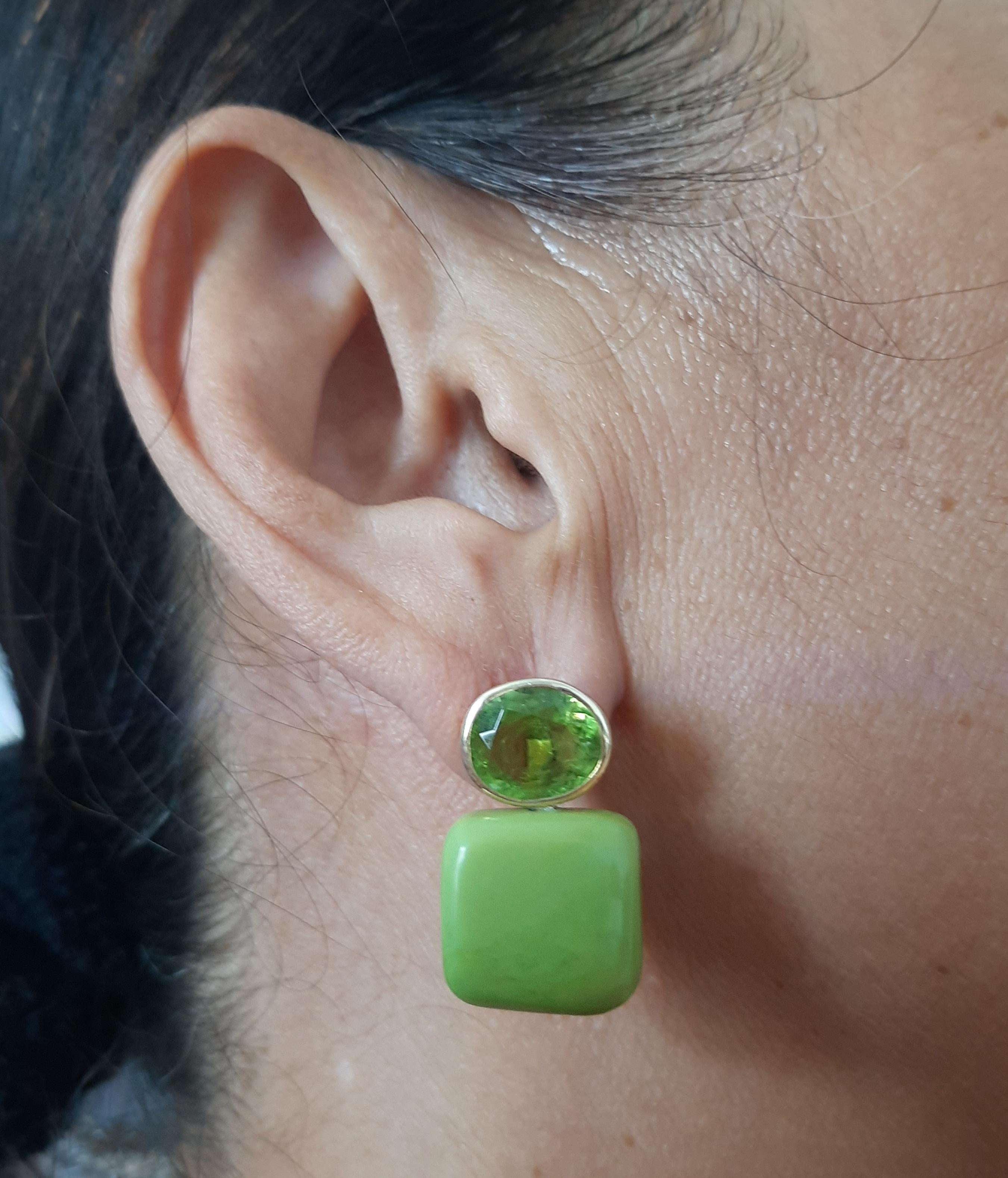 Questi semplici ma eleganti orecchini fatti a mano hanno 2 Peridot sfaccettati ovali di 8 x 10 mm incastonati in un castone in oro giallo 14 Kt alla cui sommità sono sospesi 2 Turchesi verdi del Turkmenistan a forma di cuscino di 16 x 16 mm.

Nel