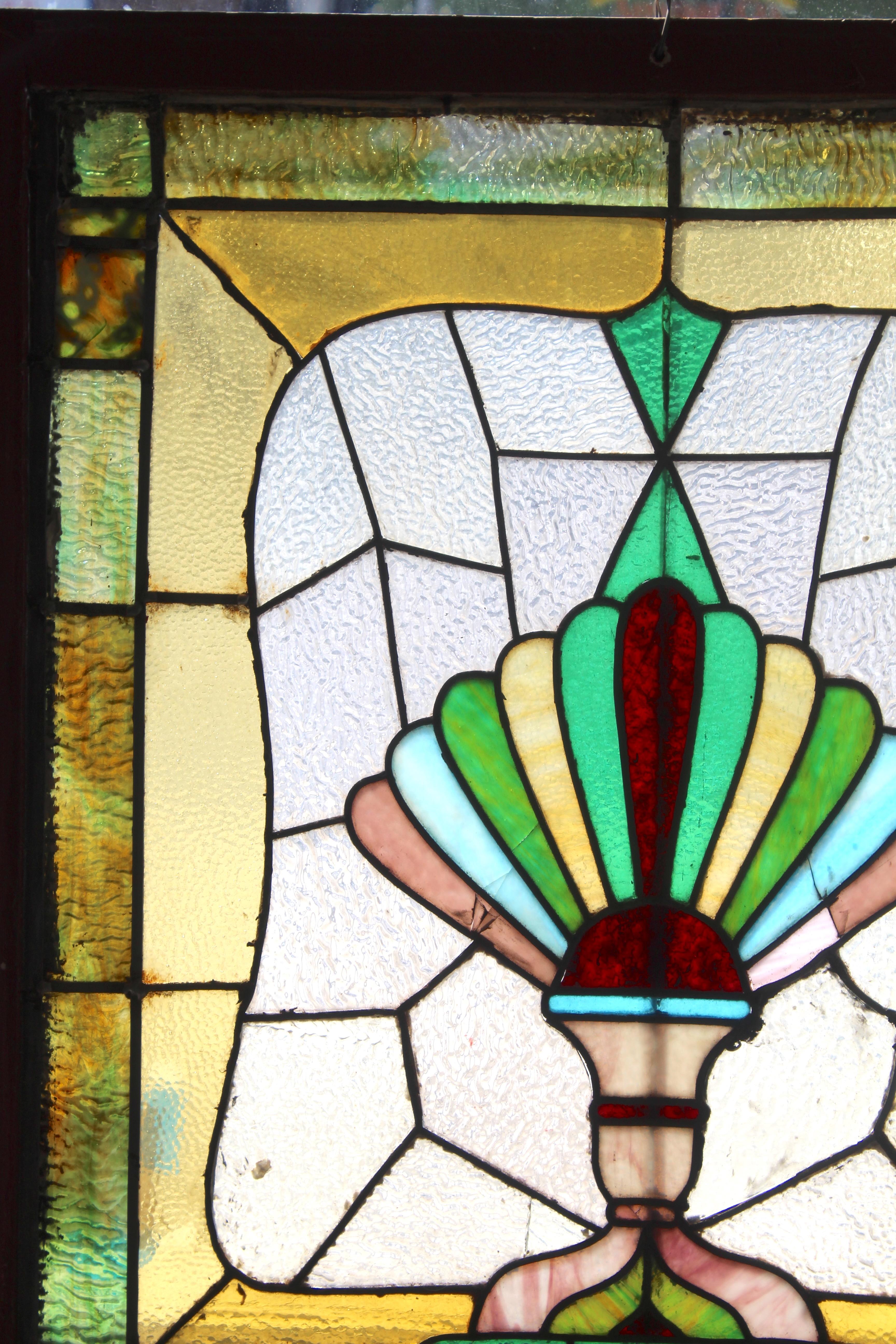 Merveilleuse fenêtre ancienne avec verre coloré. Le design plombé ressemble à une corne d'abondance avec des verres aux couleurs profondes.
Actuellement dans un cadre en bois - les dimensions totales sont celles du vitrail et du cadre.
Situé à NY 