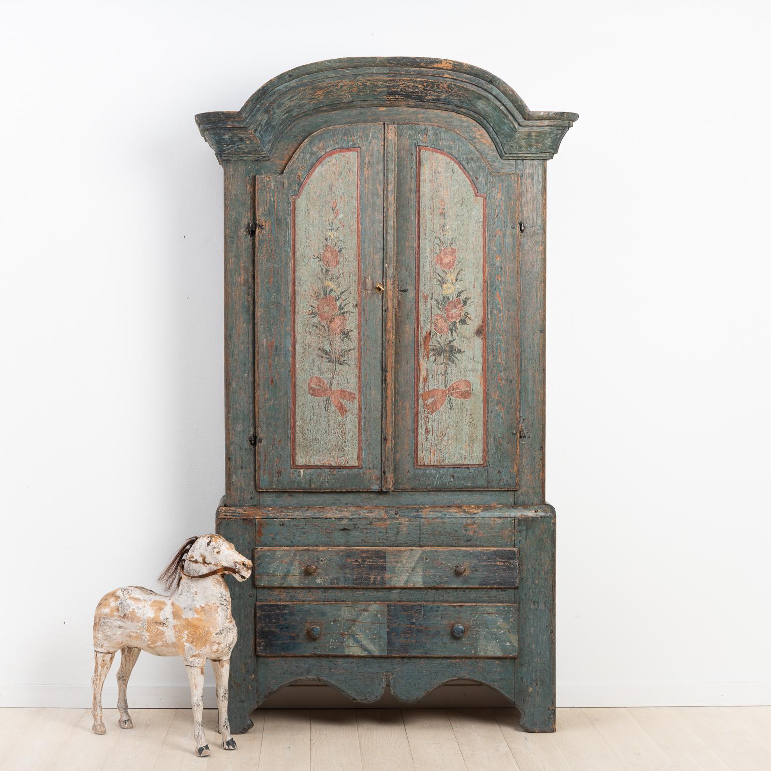 Rococo and Folk Art cabinet from Jämtland, northern Sweden. The cabinet has been scraped to the original paint. The original paint consists of marbled drawers and painted flowers on the doors. The paint on the inside is later, from around the