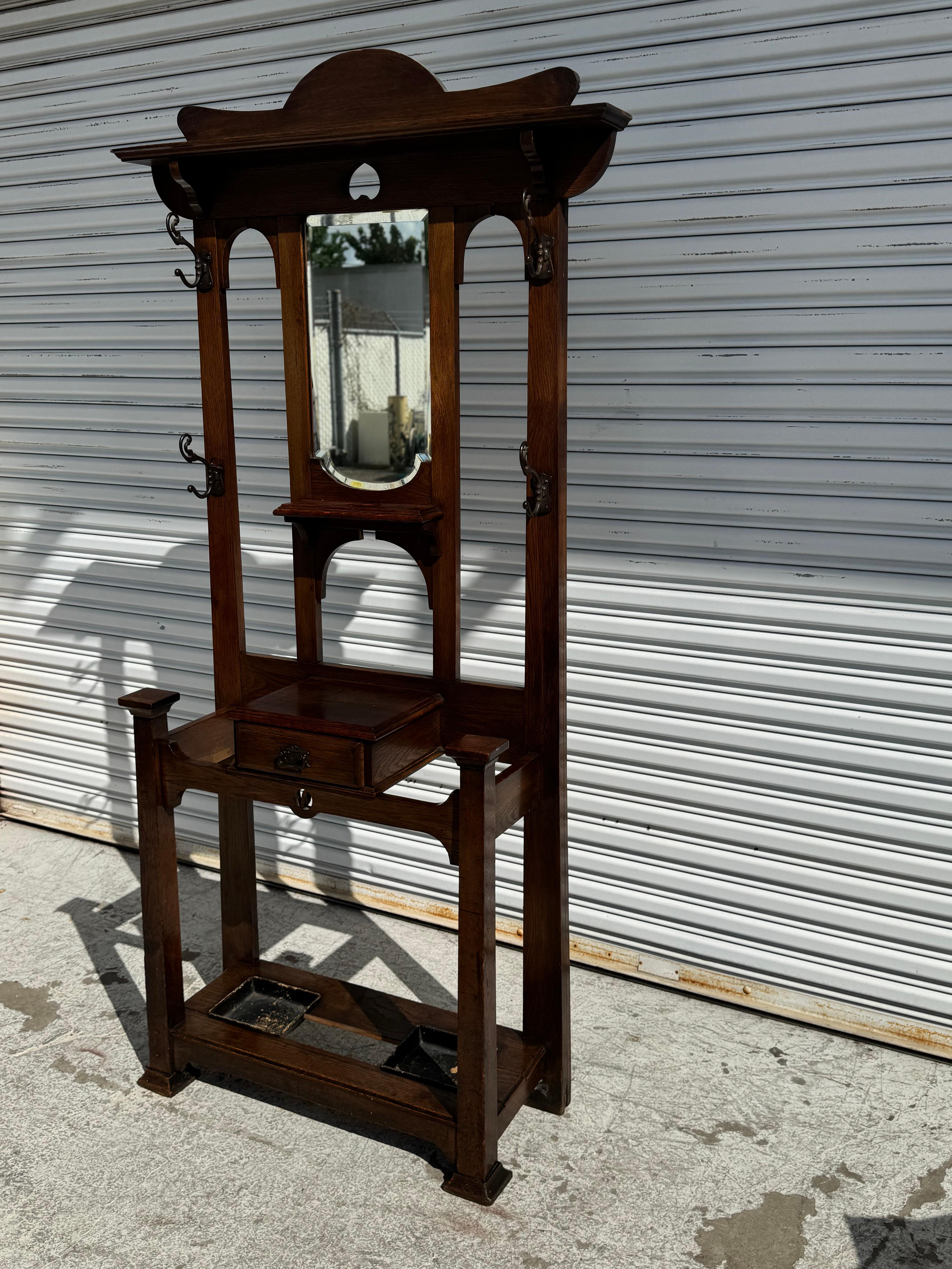 Si tratta di un portaombrelli in stile Mission.
È realizzato in stile Arts and Crafts.
È realizzato in Oak Oak e ha una ferramenta in bronzo.
Ha un cassetto per riporre gli oggetti e un paio di tegami sul fondo per riporre gli ombrelli.