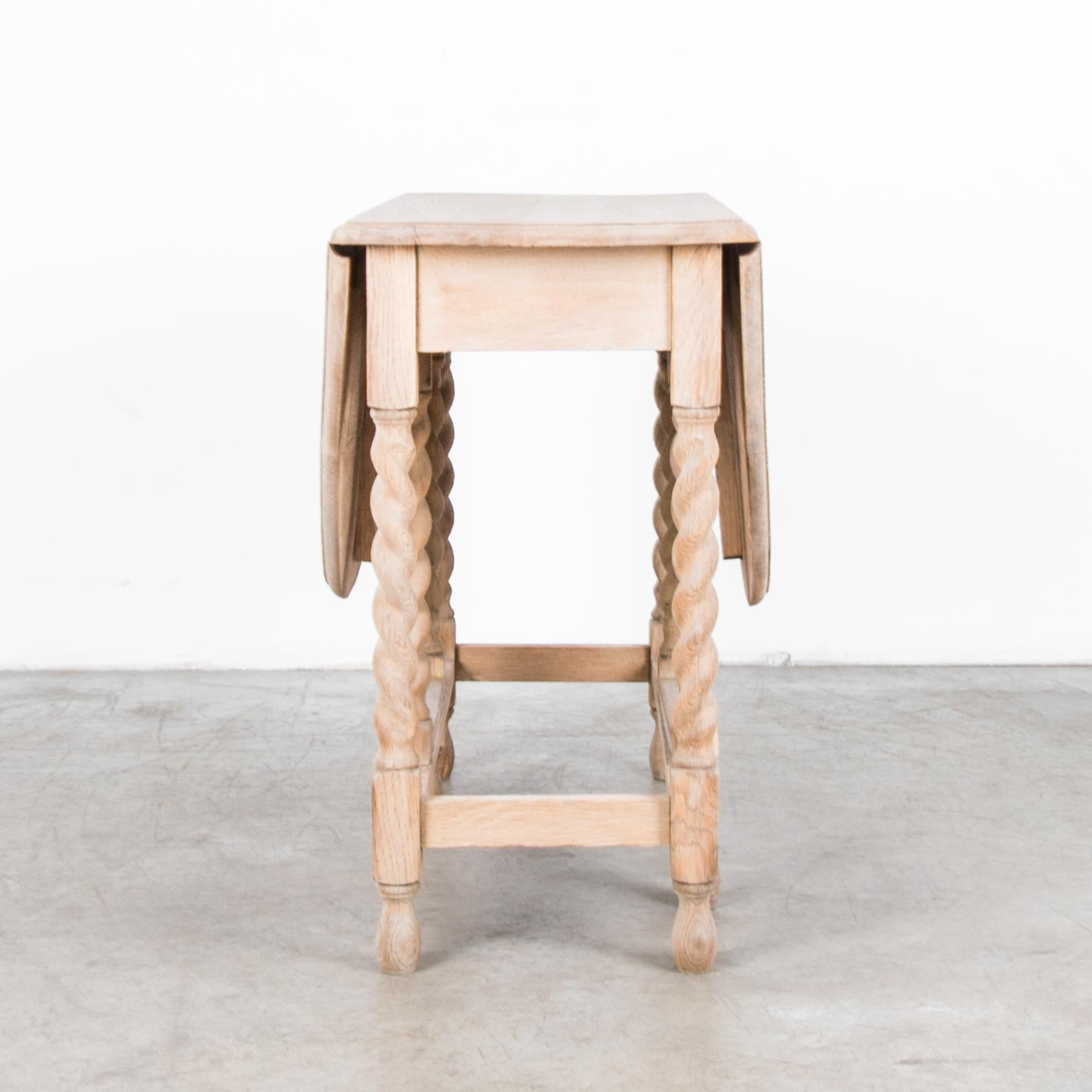 This folding gate leg table from the UK, circa 1900, features eight spiral turned legs which support a folding tabletop. Made of bleached oak, the light finish of the wood gives this table a bright, contemporary effect. Both elegant and versatile,
