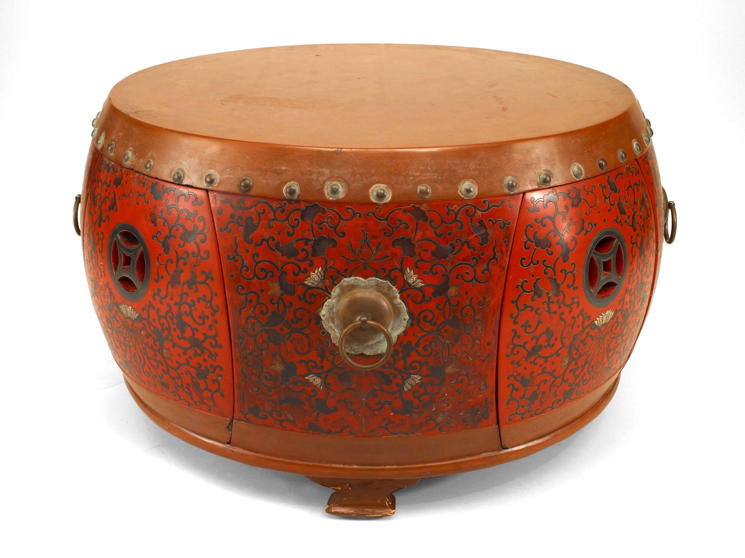 Asian Chinese-style (19/20th Century) drum-shaped coffee table with red and brown coromandel finish with brass ring handles.
