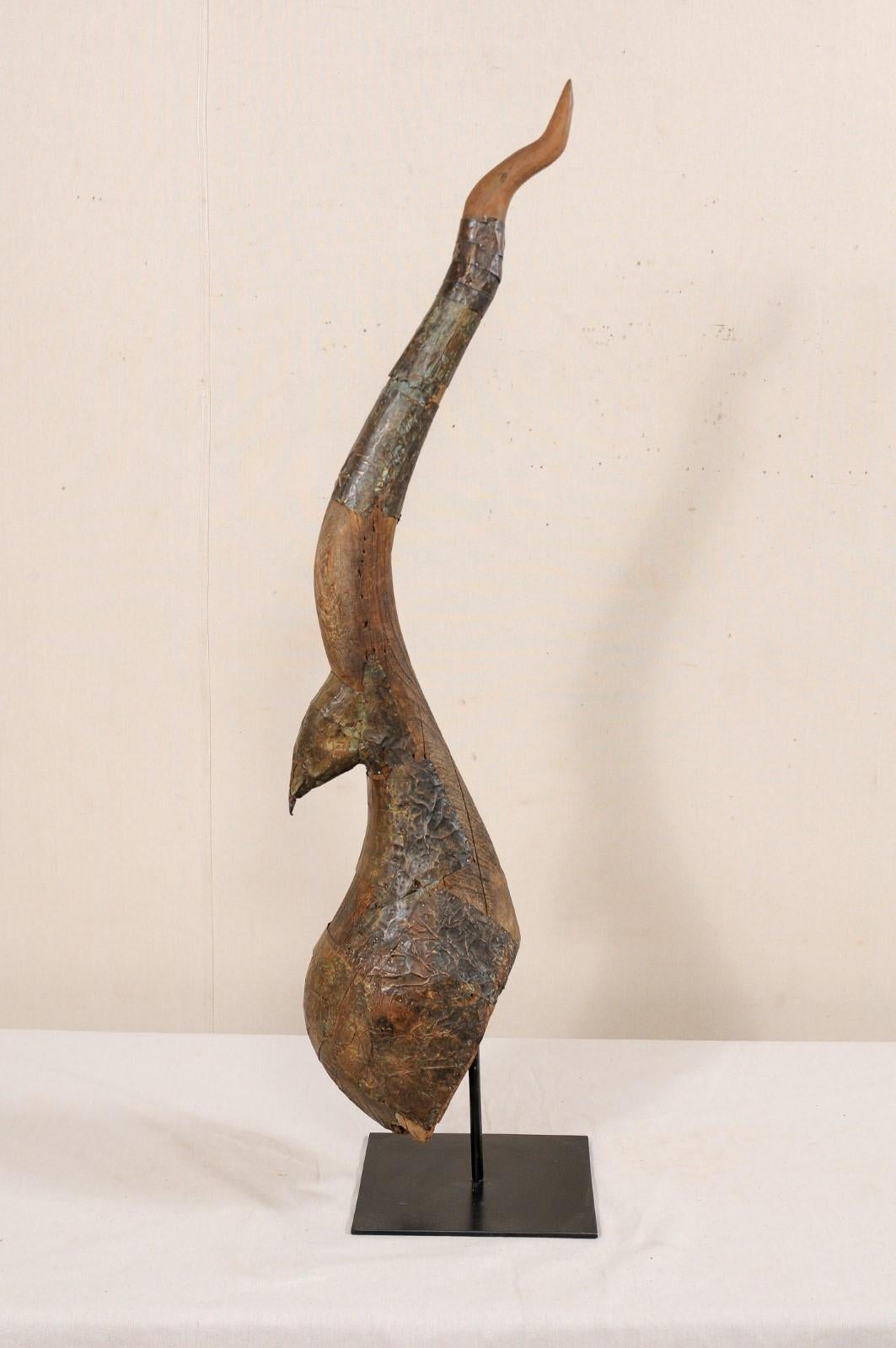 An antique carved wood chofa from Thailand, presented on custom iron stand. This elegant Thai finial, from the turn of the 19th and 20th centuries, is referred to as a 