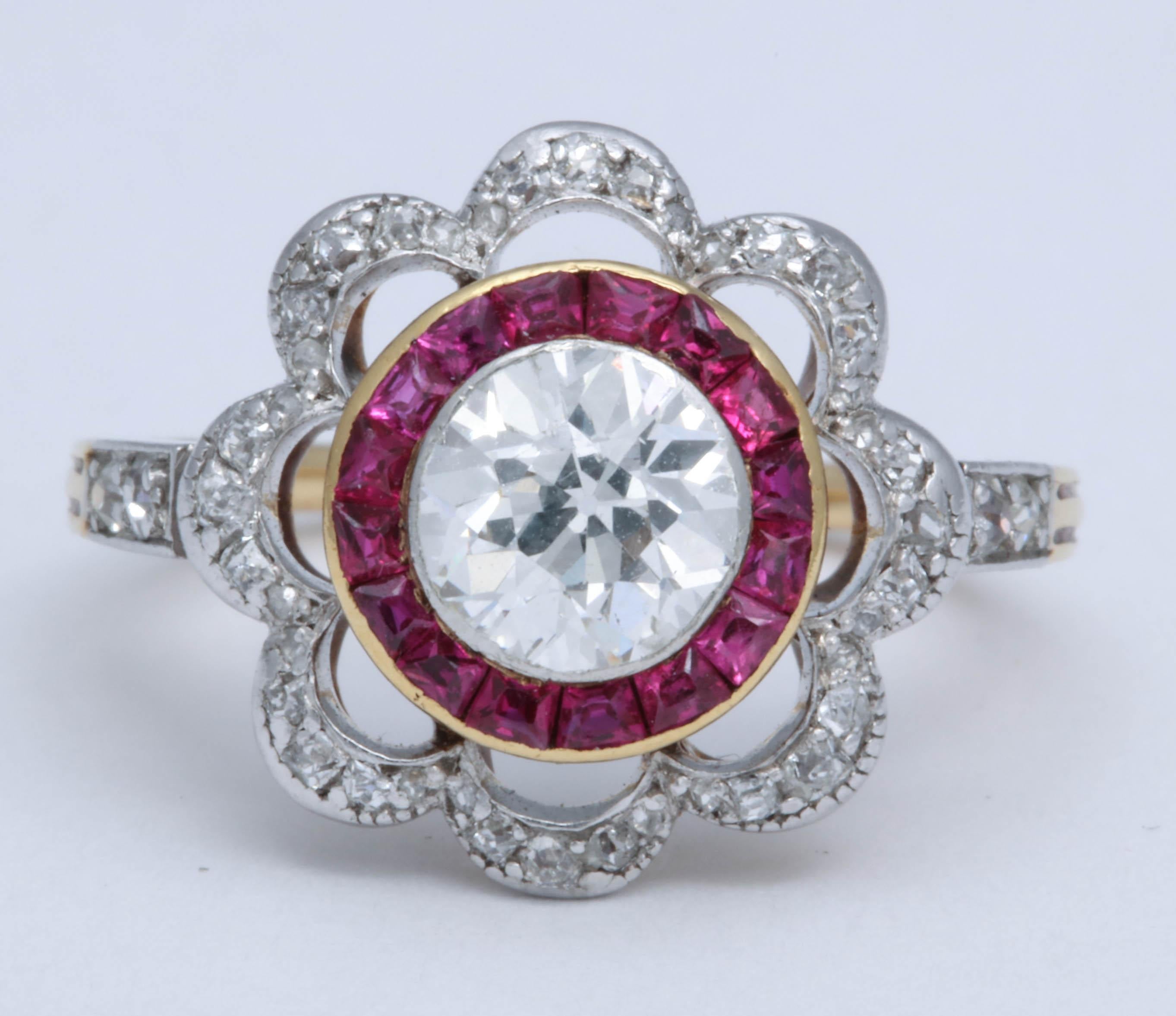 Platinum on 18K yellow gold. A center Old European cut diamond, weighing approximately .95cts is surrounded by 16 rubies. 44 Rose, single cut, and old mine cut diamonds are set around in a scalloped design and on the shoulders of the mount.