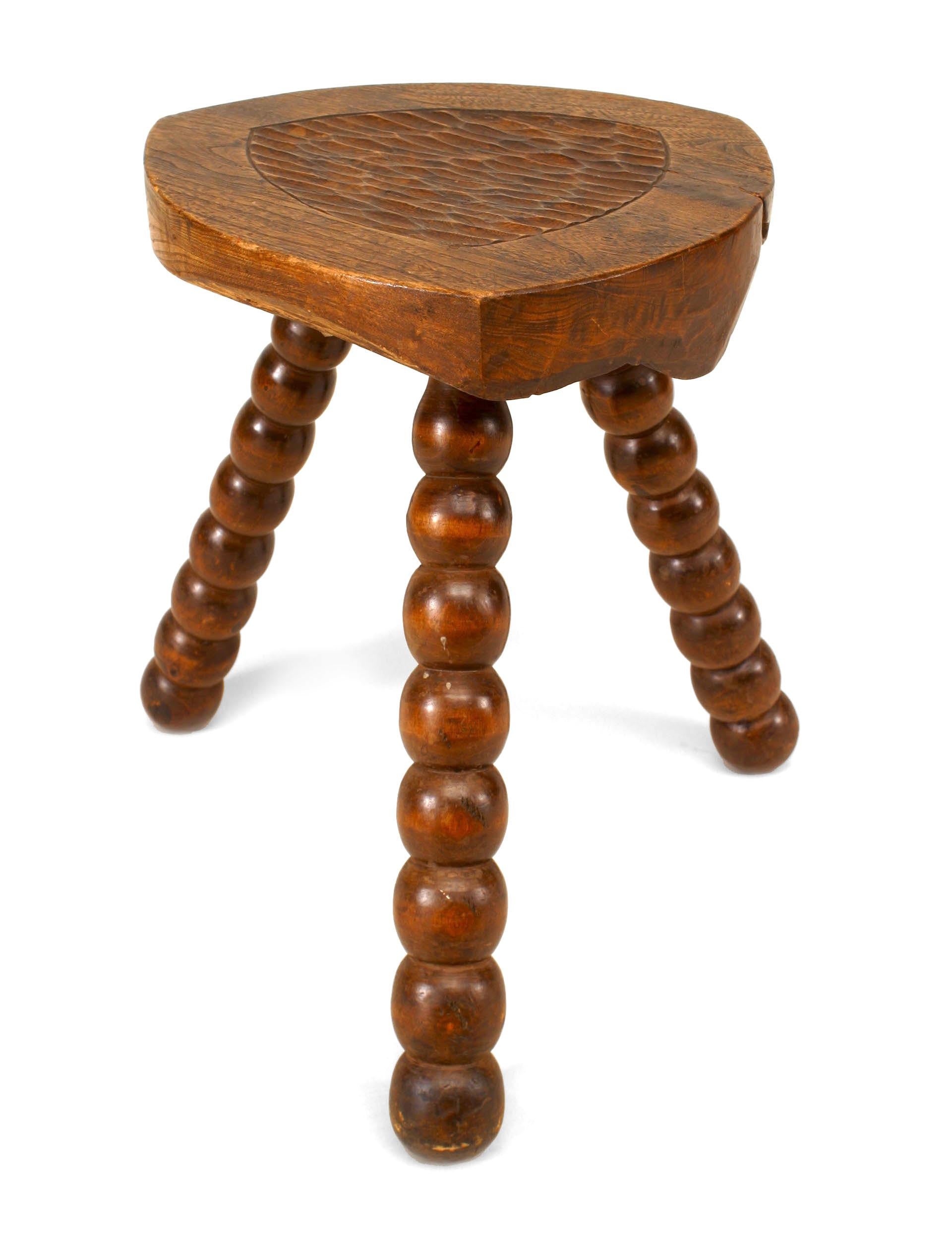 Five turn of the century English Renaissance style walnut stools, each with three spool legs and a triangular wooden seat (5 - PRICED EACH).
