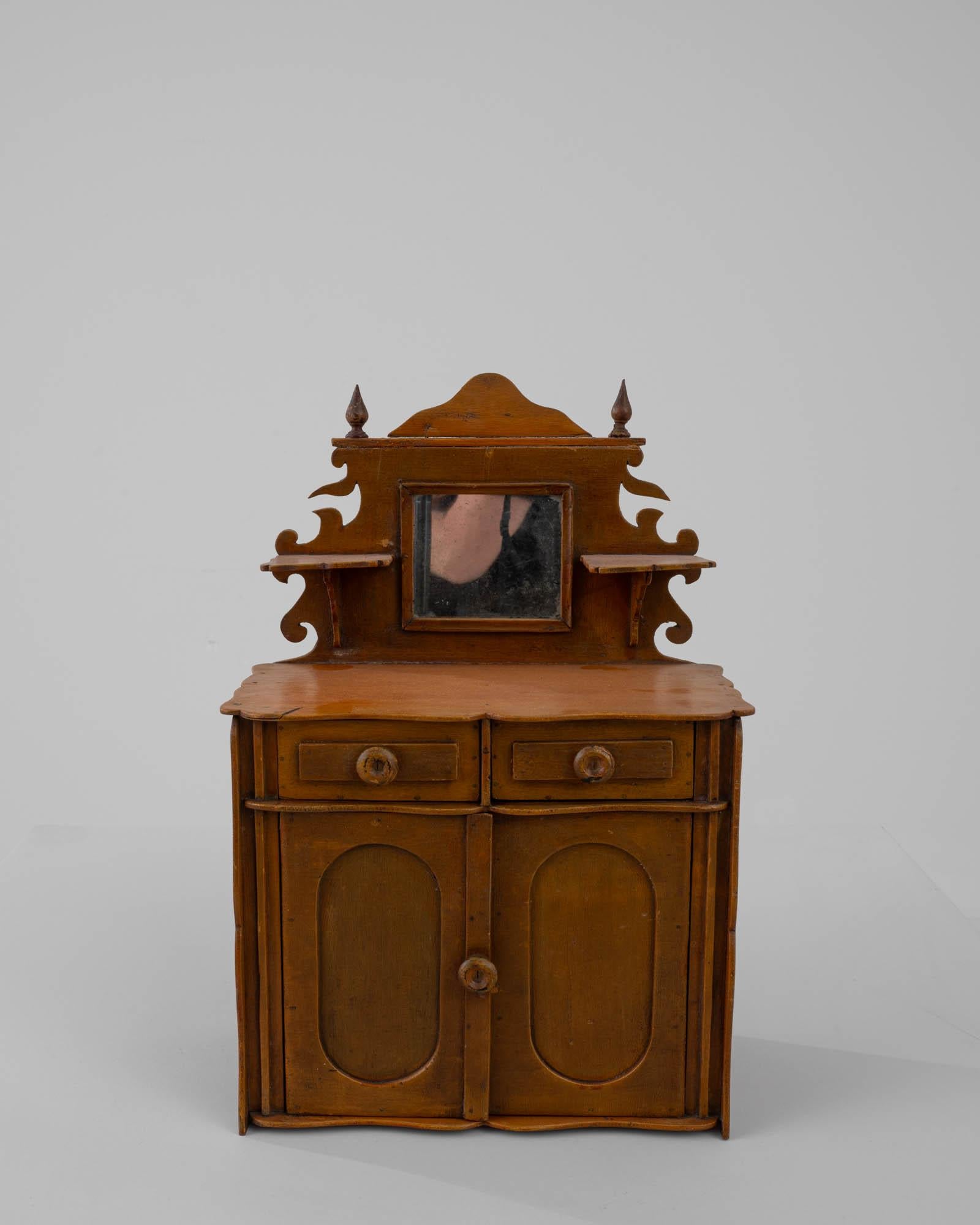 Ce modèle d'armoire en bois reflète l'art de la fabrication de meubles en miniature. Fabriquée en Europe au début du siècle, cette pièce était probablement destinée à une maison de poupée ou à un diorama. Il a manifestement été construit d'une main
