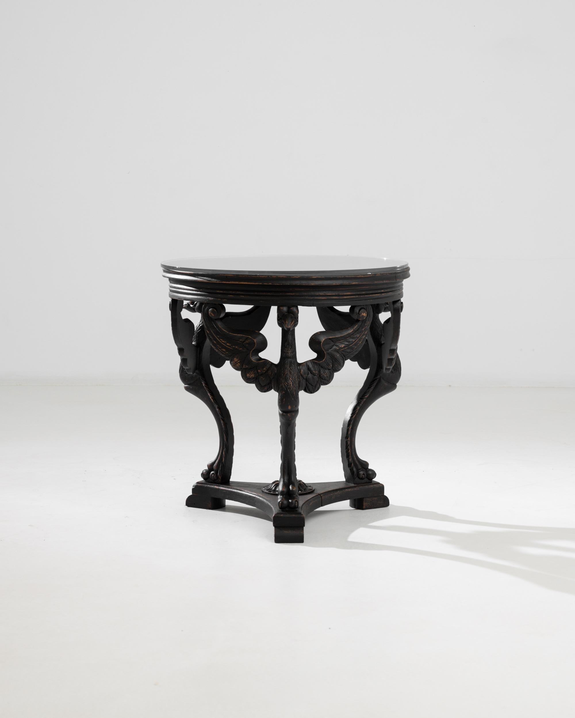 A trio of carved birds form the legs of this circular wooden table, creating a unique Belle Epoque silhouette. Made in France at the turn of the century, the birds bear a curious resemblance to a swan or an eagle. Though we cannot know why the maker