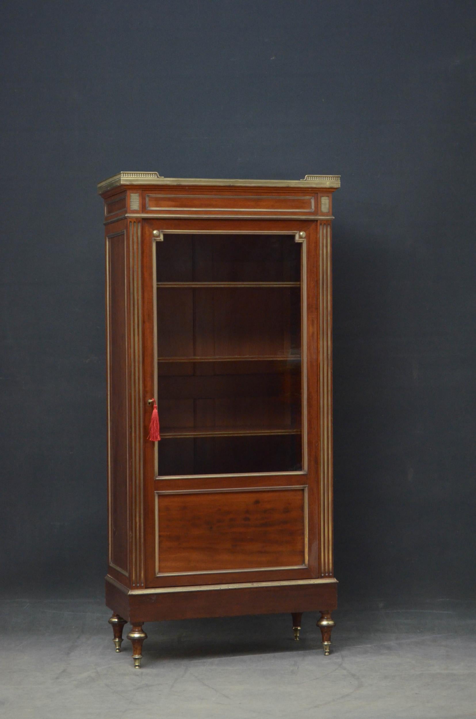 Sn5020 elegant turn of the century mahogany bookcase or china cabinet, having original veined marble top with original brass gallery to the edge above panelled and brass moulded frieze and a single glazed door with plum pudding mahogany panel to the