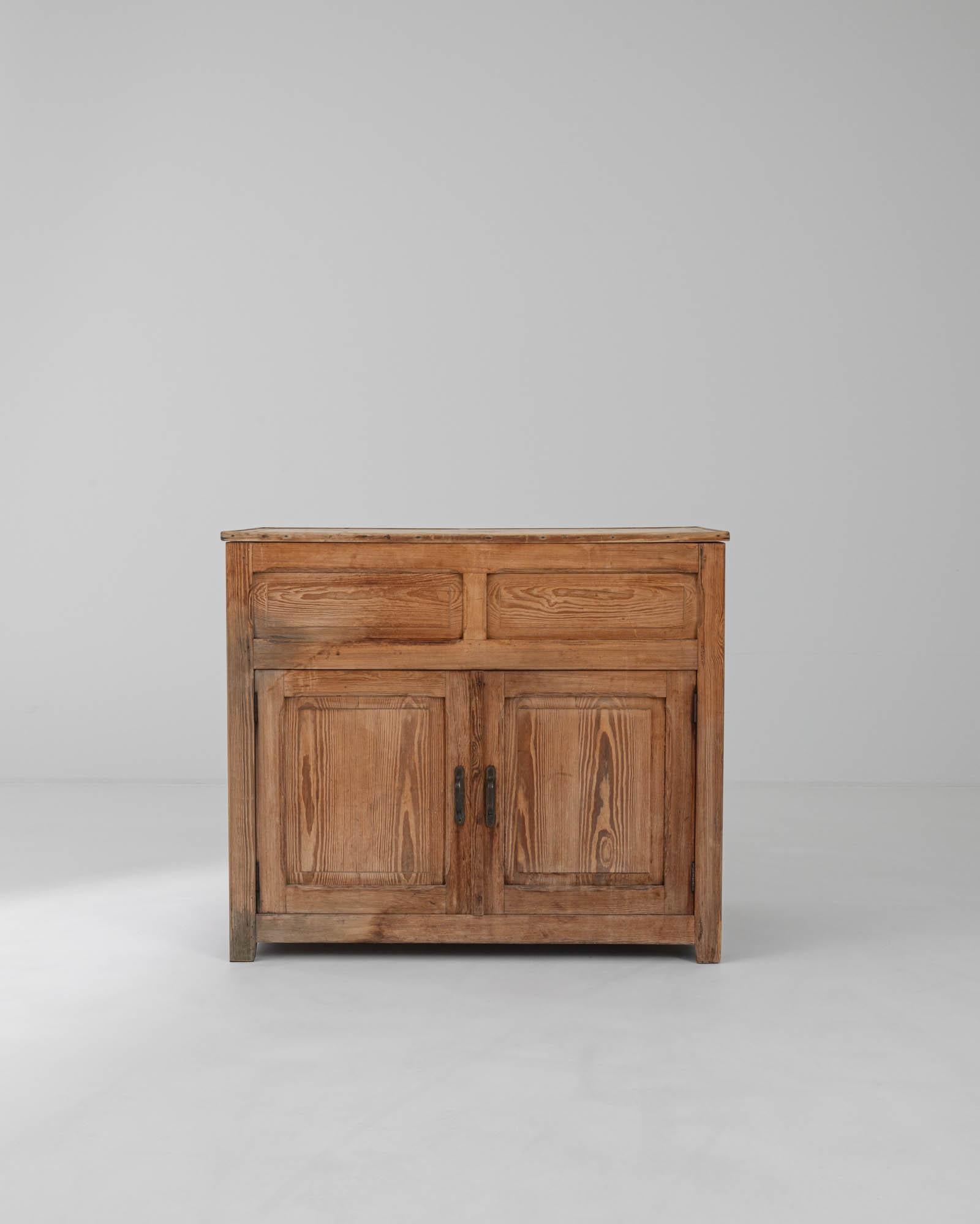 This delightful vintage wooden buffet offers a simple country design with a bright natural finish. Built in France at the turn of the century, deep cupboards offer ample storage space, while the upper surface of the cabinet lifts up to reveal a