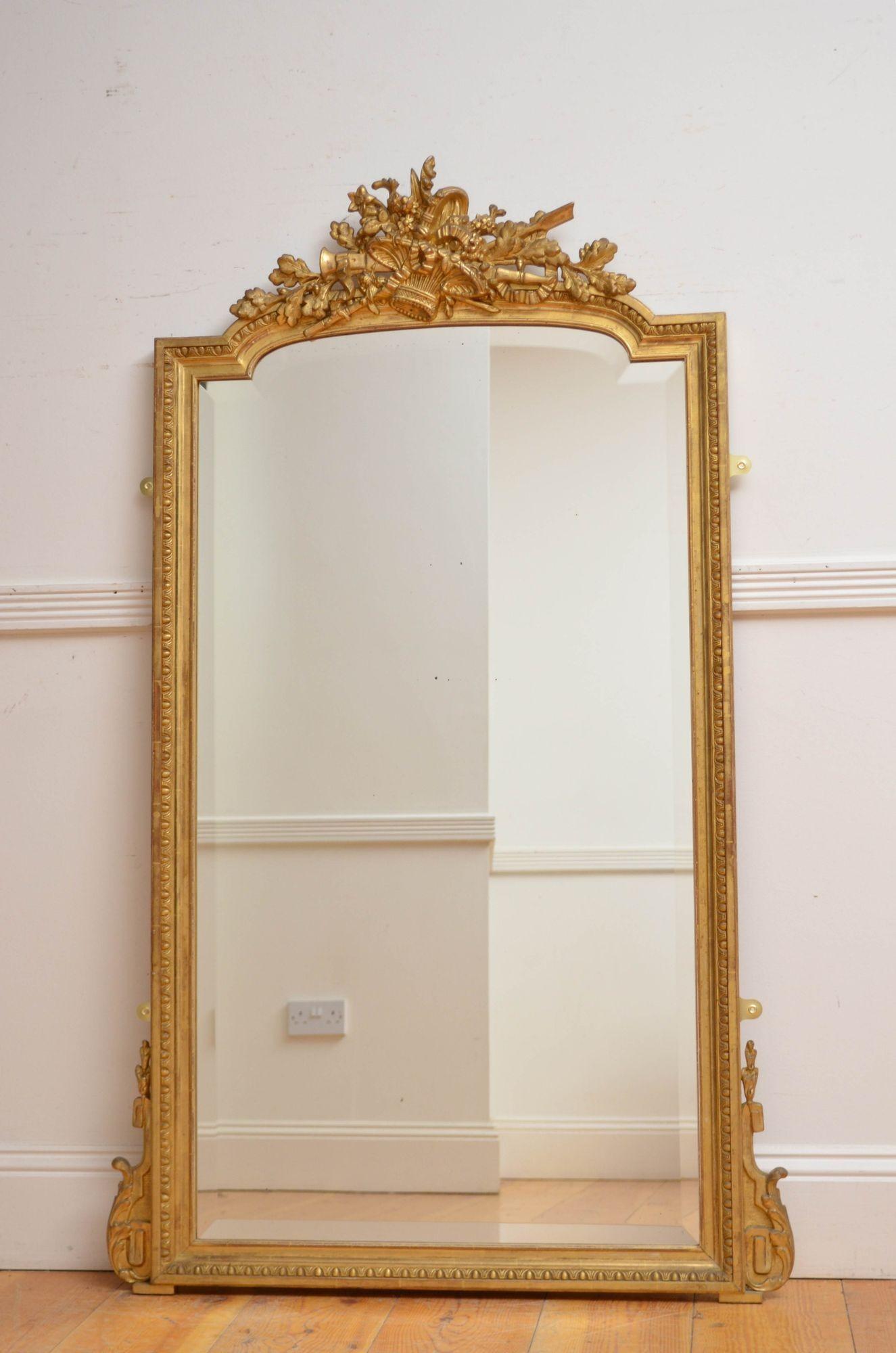Sn5552 Attractive turn of the century French giltwood wall mirror or pier mirror, having original bevelled edge glass with some foxing in moulded and gilded frame with egg and dart moulding, leafy scrolls to the base and intricate centre crest with