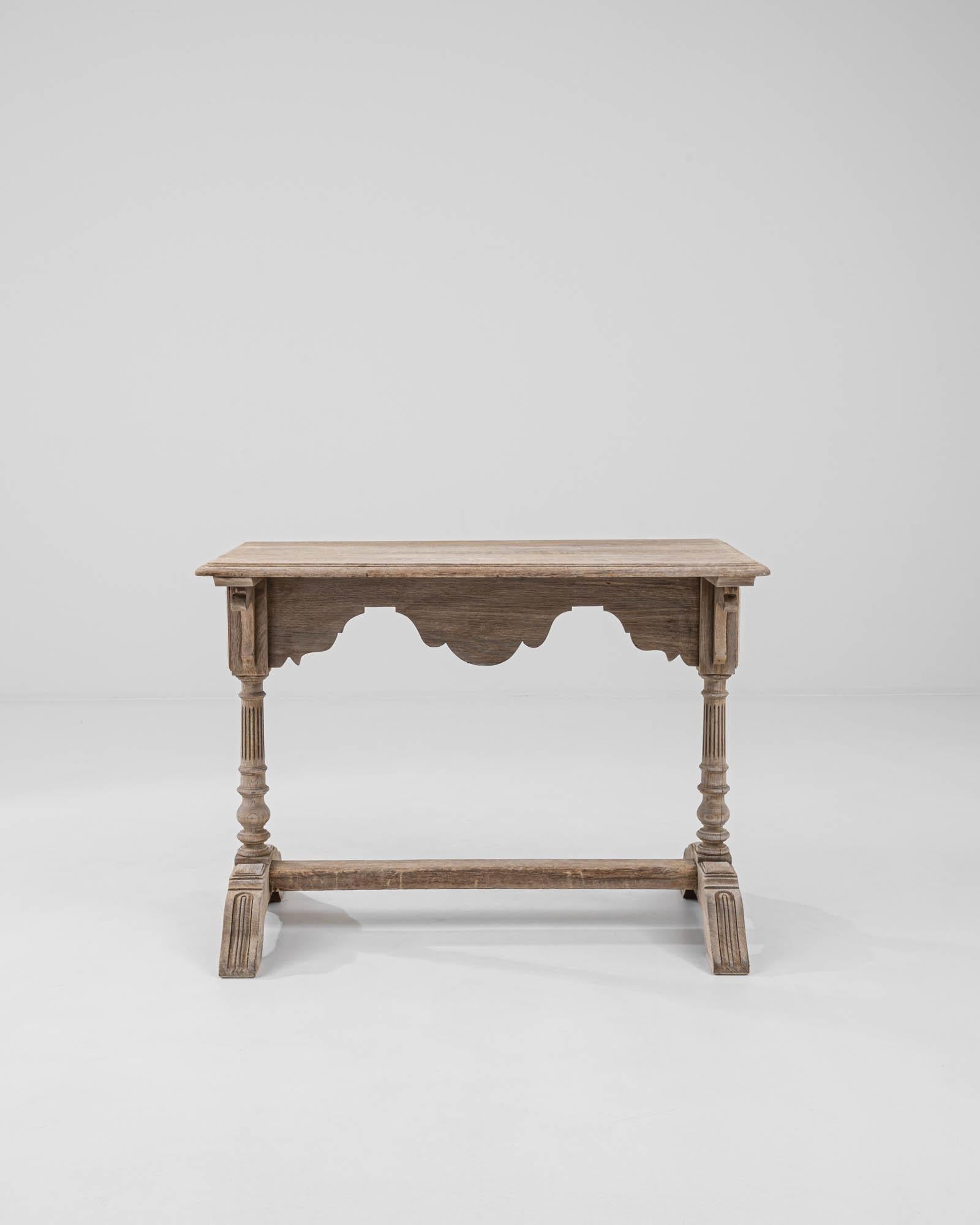 This vintage trestle table in natural oak cuts an elegant silhouette. Made in France at the turn of the century, the design combines styles and decorative techniques from a variety of eras into a light and harmonious composition. The trestle form,