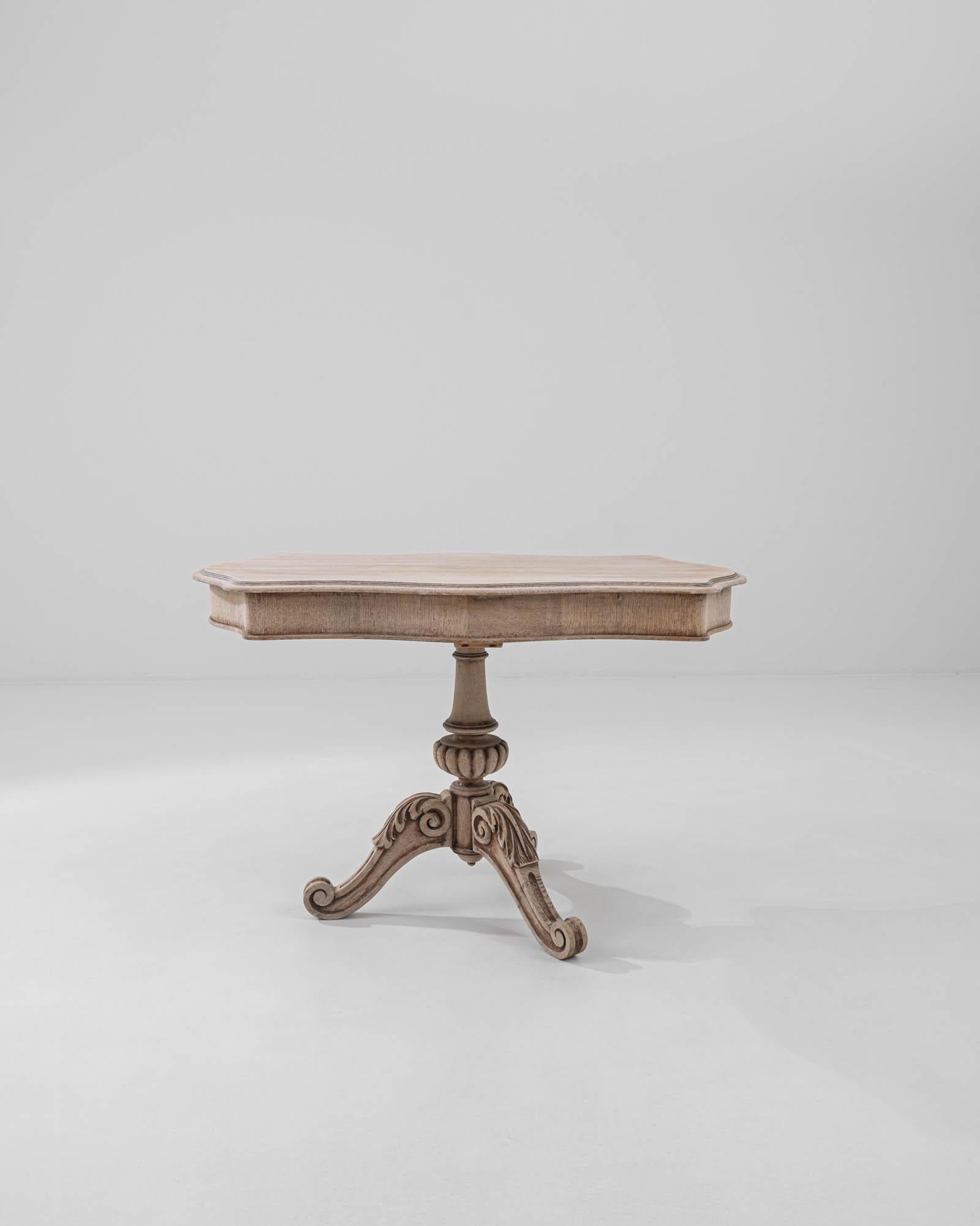 Intricate carvings combined with a distinctive shape give this vintage oak side table a unique appeal. Made in France at the turn of the century, the design takes inspiration from the extravagant forms of Baroque furniture: the graceful contours of