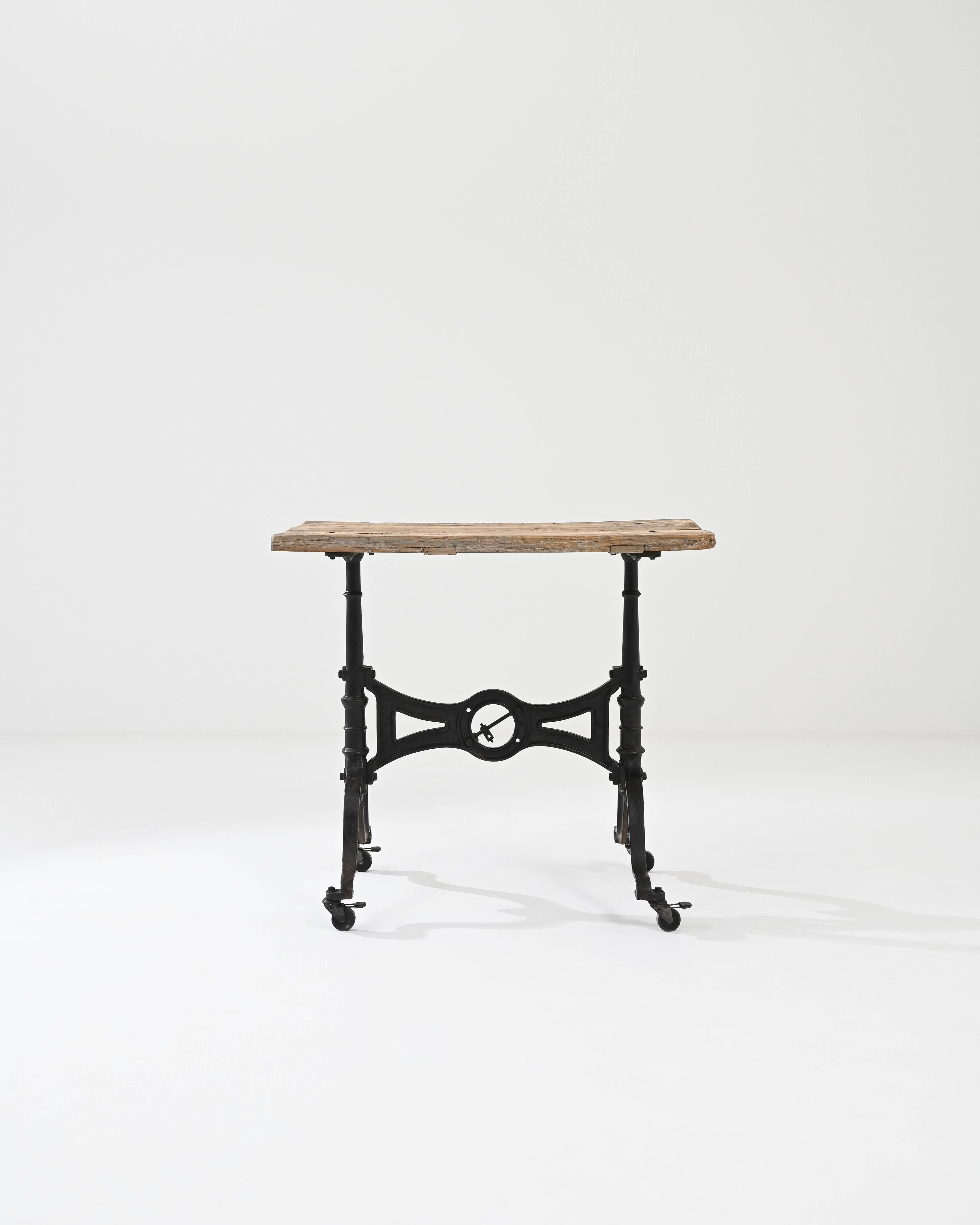 This bistro table provides a charming and idiosyncratic vintage piece. Made in France at the turn of the century, a metal frame creates a striking silhouette: bold curves and refined symmetries forged in metal reflect the materials and aesthetics of