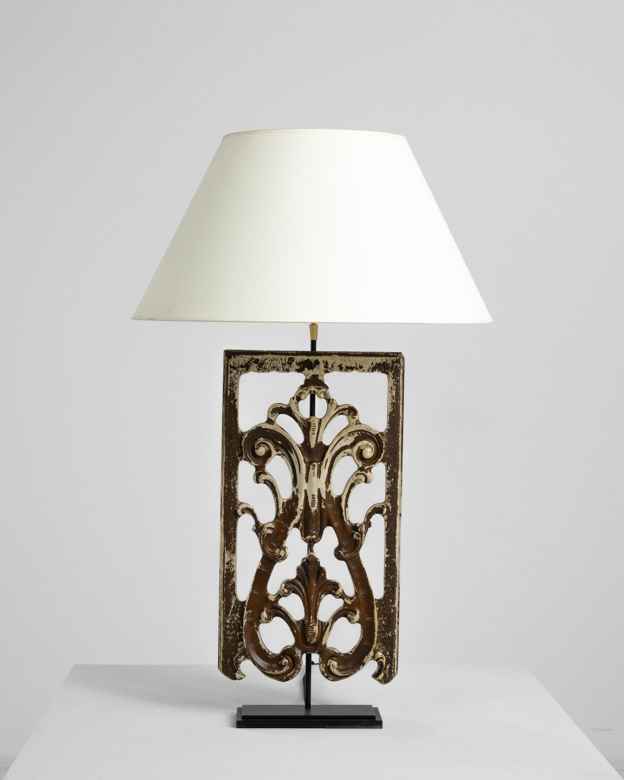 Made from a piece of reclaimed wooden ornament, this table lamp makes a truly unique accent. The base was originally carved in turn of the century France, and most likely formed part of an architectural composition. When the lamp is illuminated, the