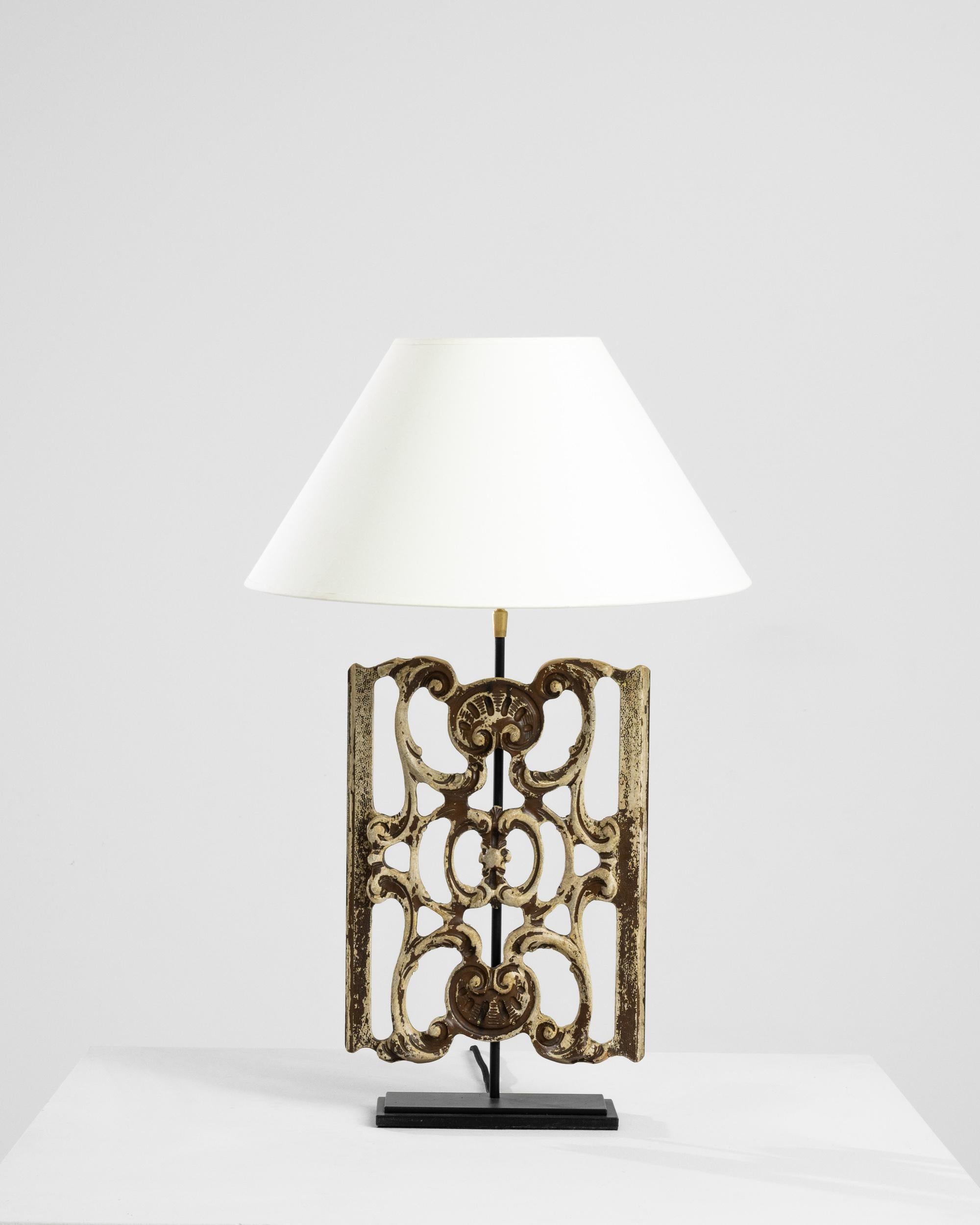 Made from a piece of reclaimed wooden ornament, this table lamp makes a truly unique accent. The base was originally carved in turn of the century France, and most likely formed part of an architectural composition. When the lamp is illuminated, the