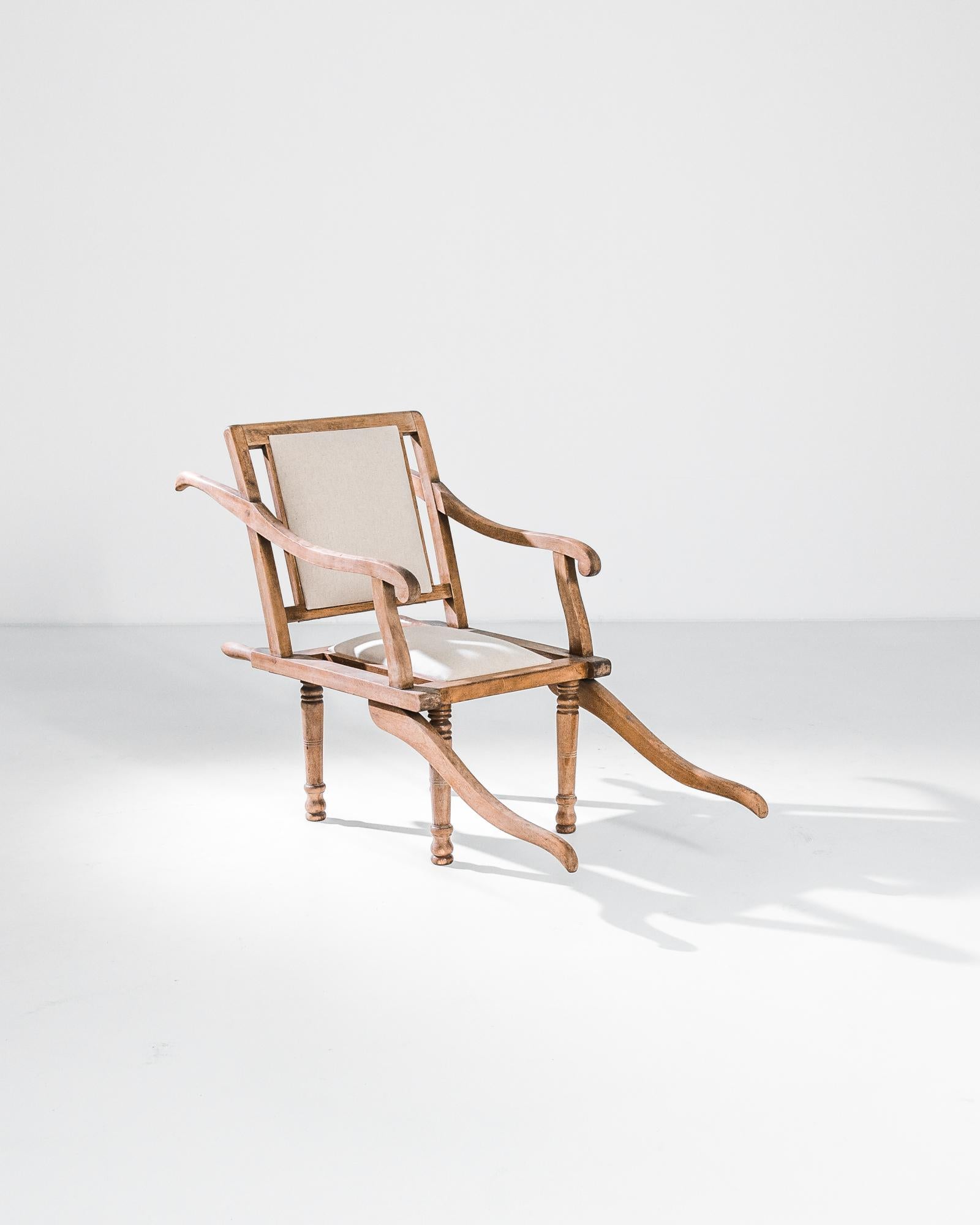 Cet élégant fauteuil en bois a été fabriqué au début du siècle en France par le fabricant de mobilier militaire Mac Kain. La silhouette frappante, avec ses accoudoirs en bois sinueux et ses bras coulissants à la base, devait à l'origine avoir un but