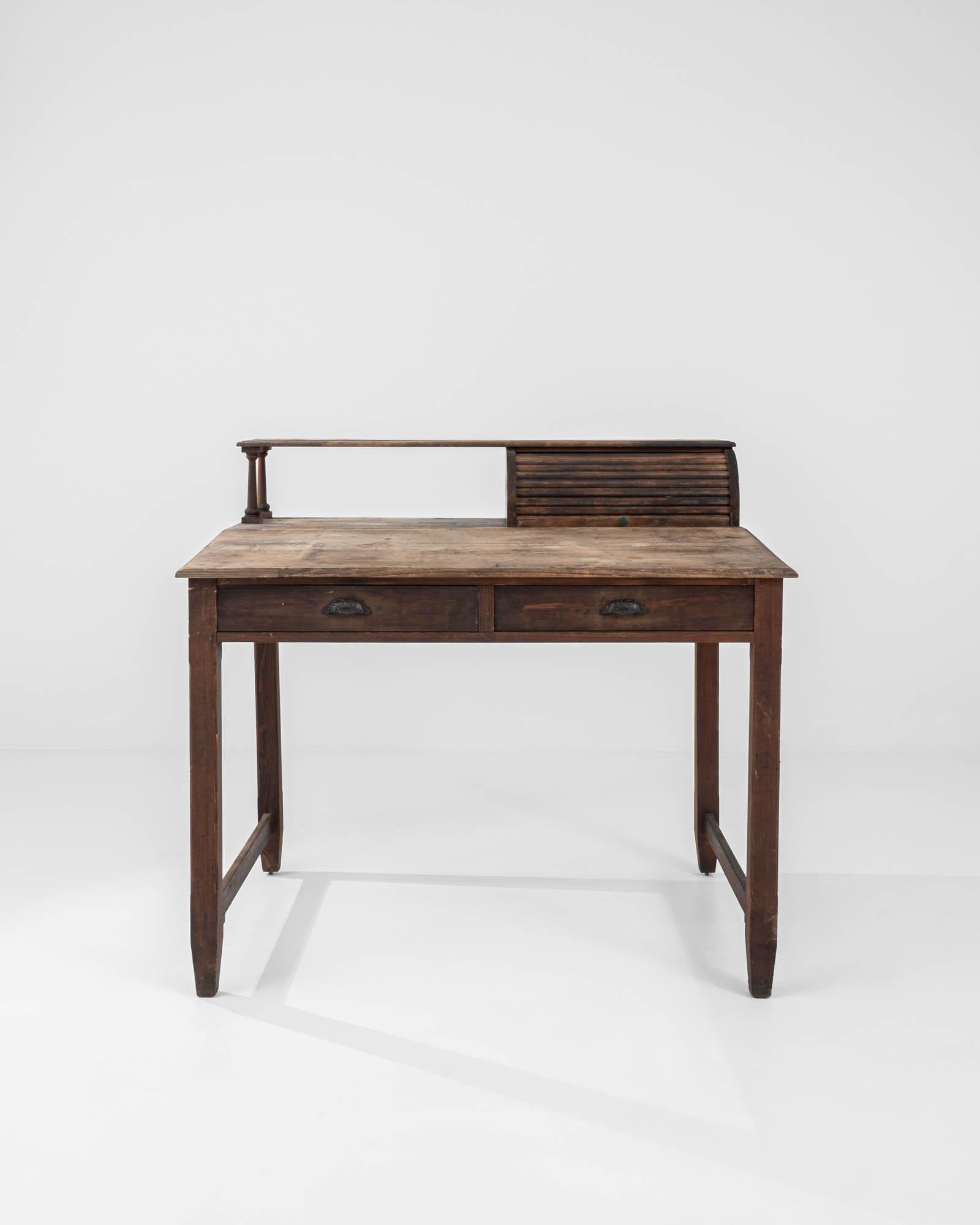 The unique design of this vintage wooden writing desk combines a distinguished character with charming eccentricity. Built in France at the turn of the century, the broad tabletop is set at a slight angle, encouraging a comfortable working position.