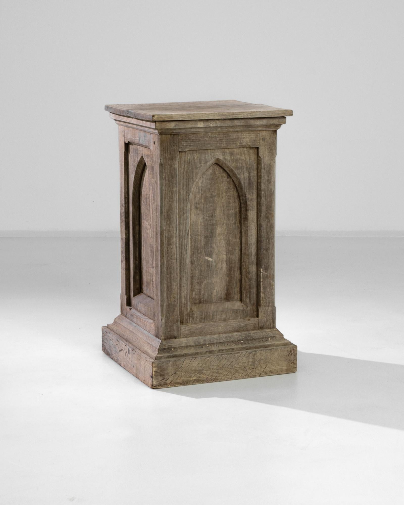 This antique bleached oak pedestal was crafted in France, circa 1900. A dignified case stands on a stair-step base mirrored by a beveled top, and carved with ogives. The wood has been restored to reveal its original grain, exposing a natural umber