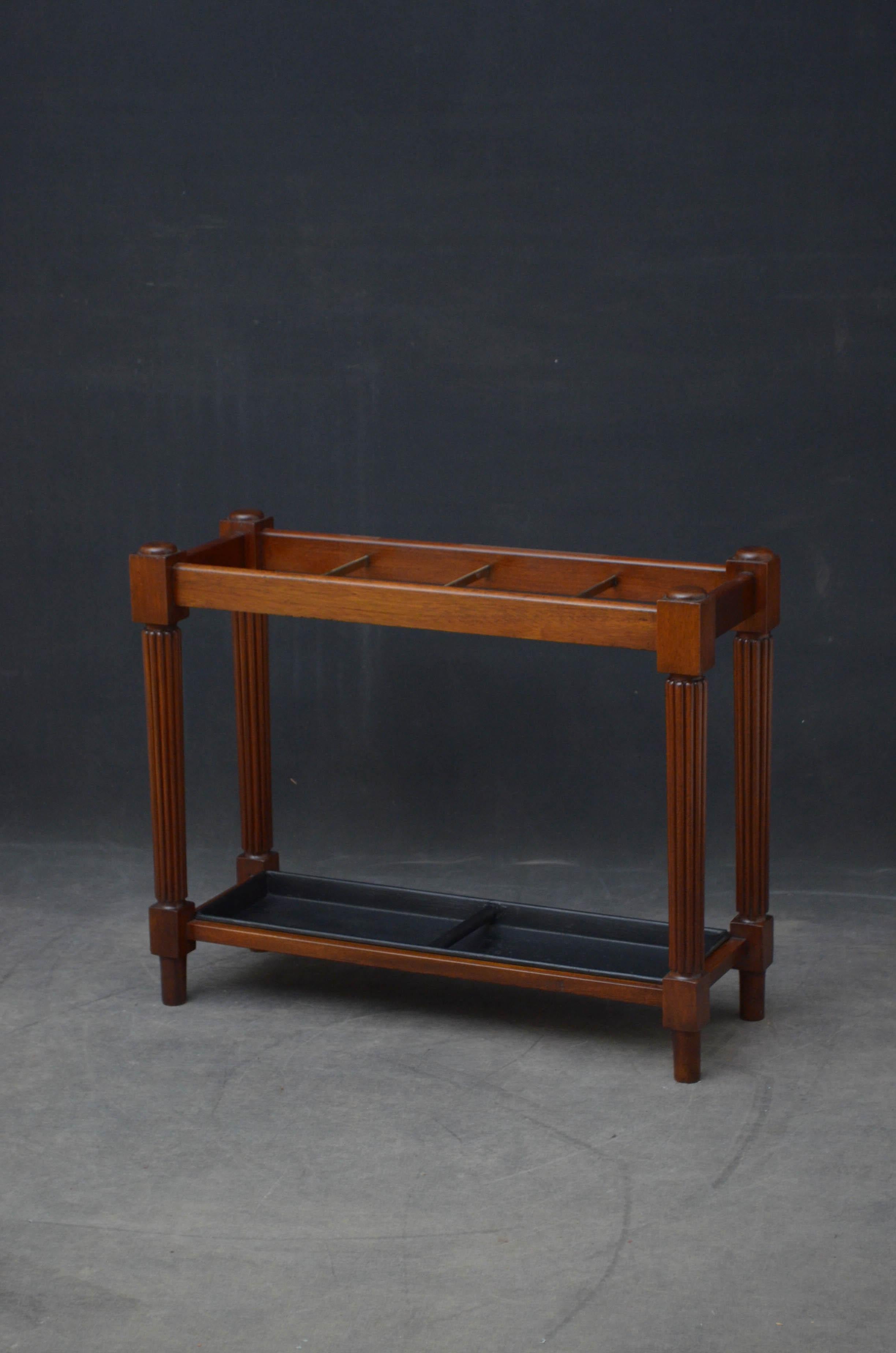 Sn4816 turn of the century walking cane stand or umbrella stand in mahogany, having 3 brass dividers and original removable drip tray on turned, reeded and tapered supports terminating in turned feet.

This antique umbrella stand has been