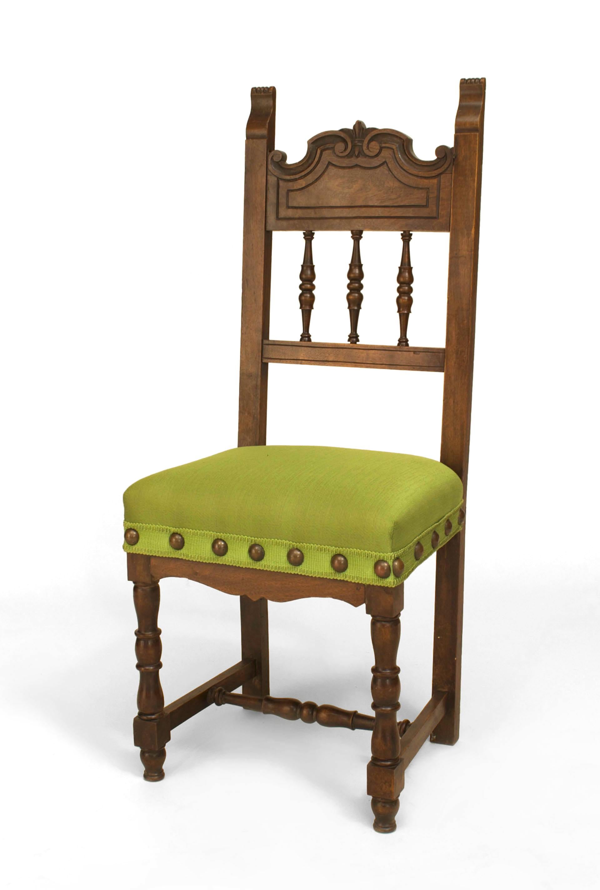 Turn of the century Spanish Renaissance style walnut spindle back side chair with a stretcher and green upholstered seat.