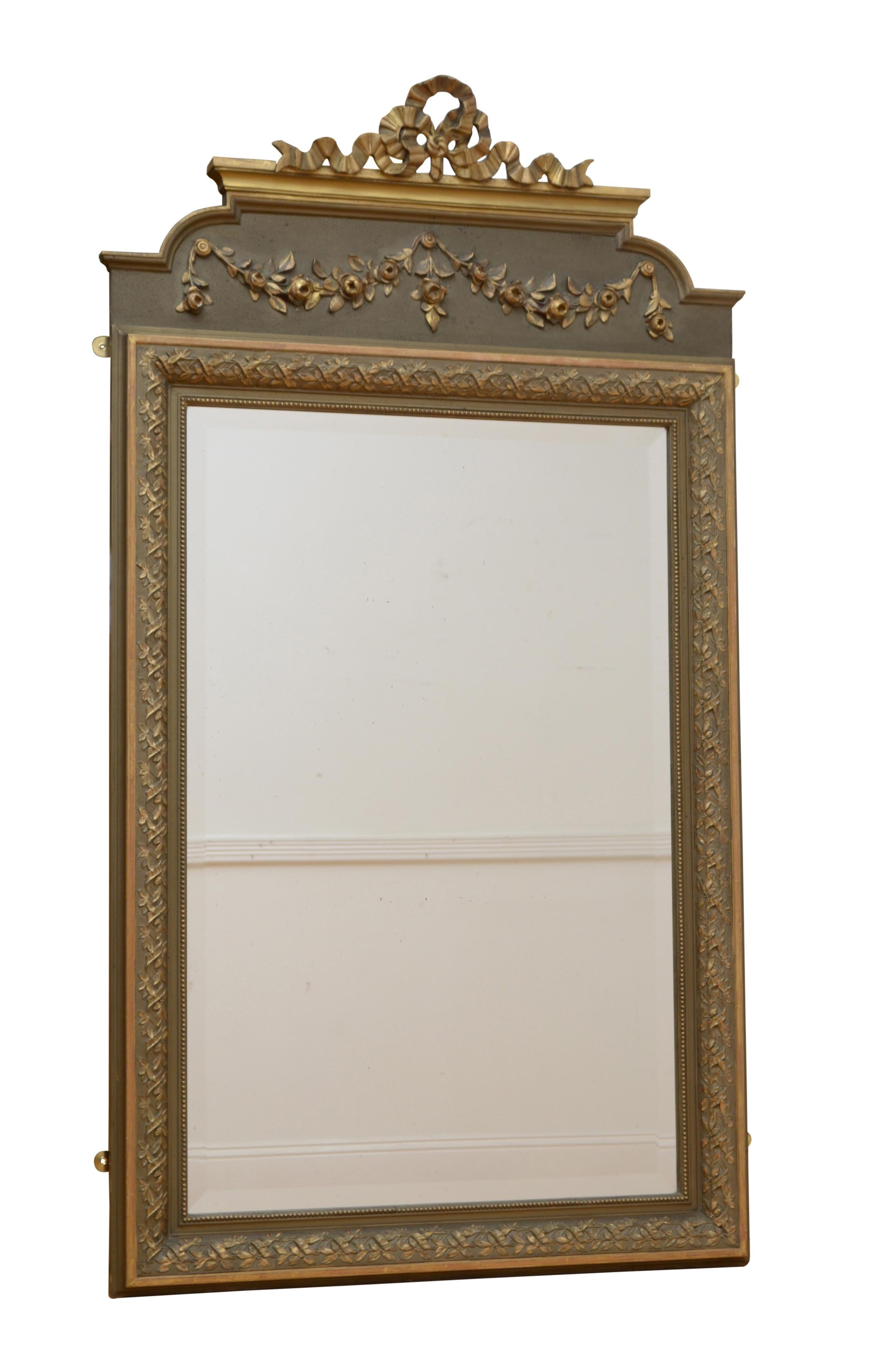 0234 attractive French wall mirror, having original bevelled edge glass in moulded and flower carved gilded frame with floral swags on a olive green board and gilded bow to the top. This antique mirror retains its original glass and original paint